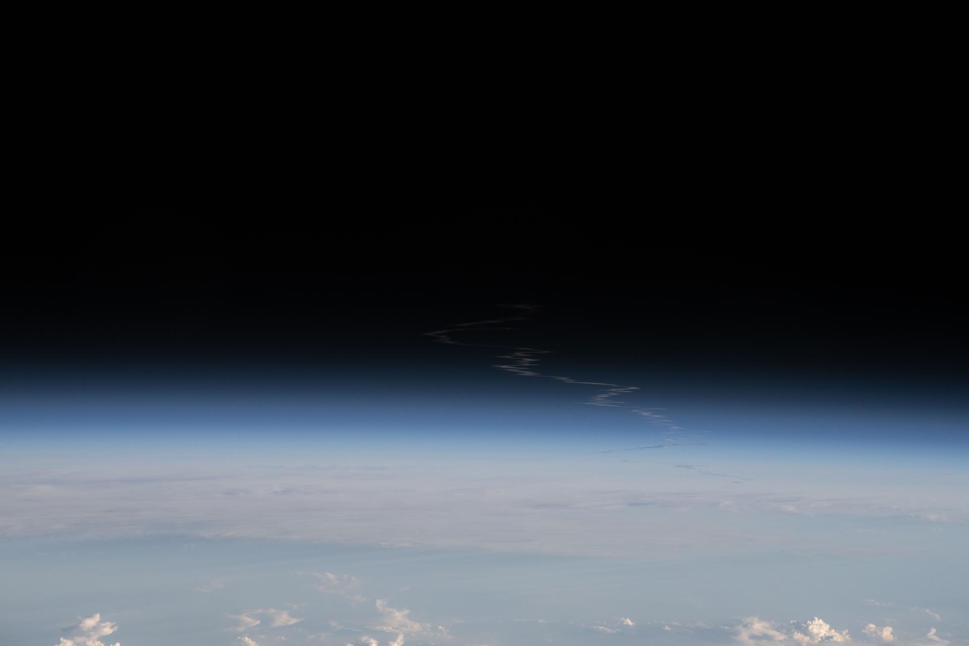 The exhaust plume left behind by the SLS (Space Launch System) rocket that launched Artemis II, NASA’s first crewed mission to the Moon since December 1972, dissipates in the Earth's atmosphere in this photograph from the International Space Station. The orbital outpost was soaring 266 miles above Wisconsin at the time of this photograph.
