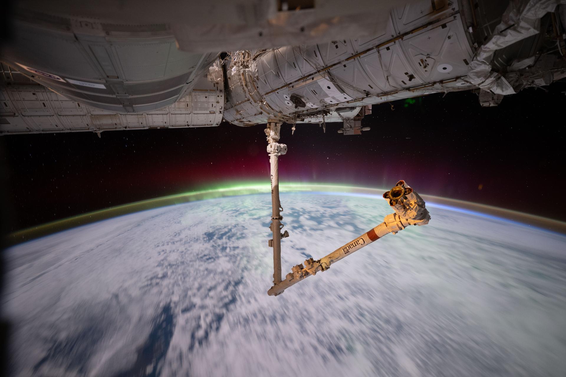 iss074e0433177 (April 3, 2026) --- The aurora australis crowns Earth’s atmosphere in this photograph taken at approximately 3:13 a.m. local time from the International Space Station as it orbited 269 miles above the Indian Ocean east of the French Southern and Antarctic Lands. In the foreground, the Canadarm2 robotic arm extends from a power and data grapple fixture attached to the Harmony module. Credit: NASA/Chris Williams