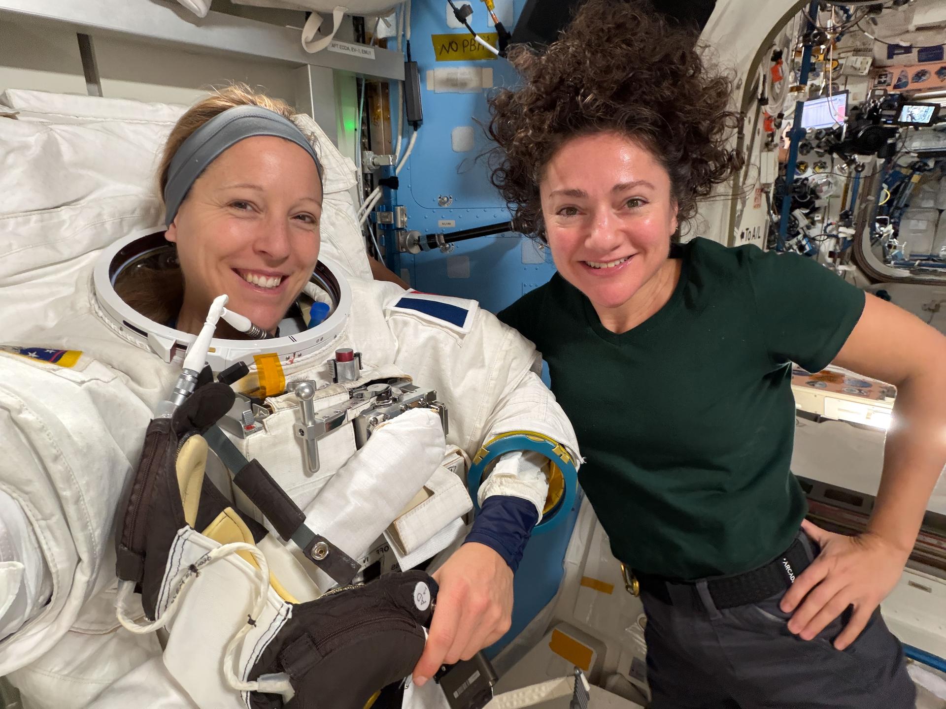 Expedition 74 flight engineers Sophie Adenot of ESA (European Space Agency) and Jessica Meir of NASA pose for a portrait inside the International Space Station’s Quest airlock. Adenot was trying on a spacesuit to verify its comfort, mobility, and functionality with assistance from Meir.