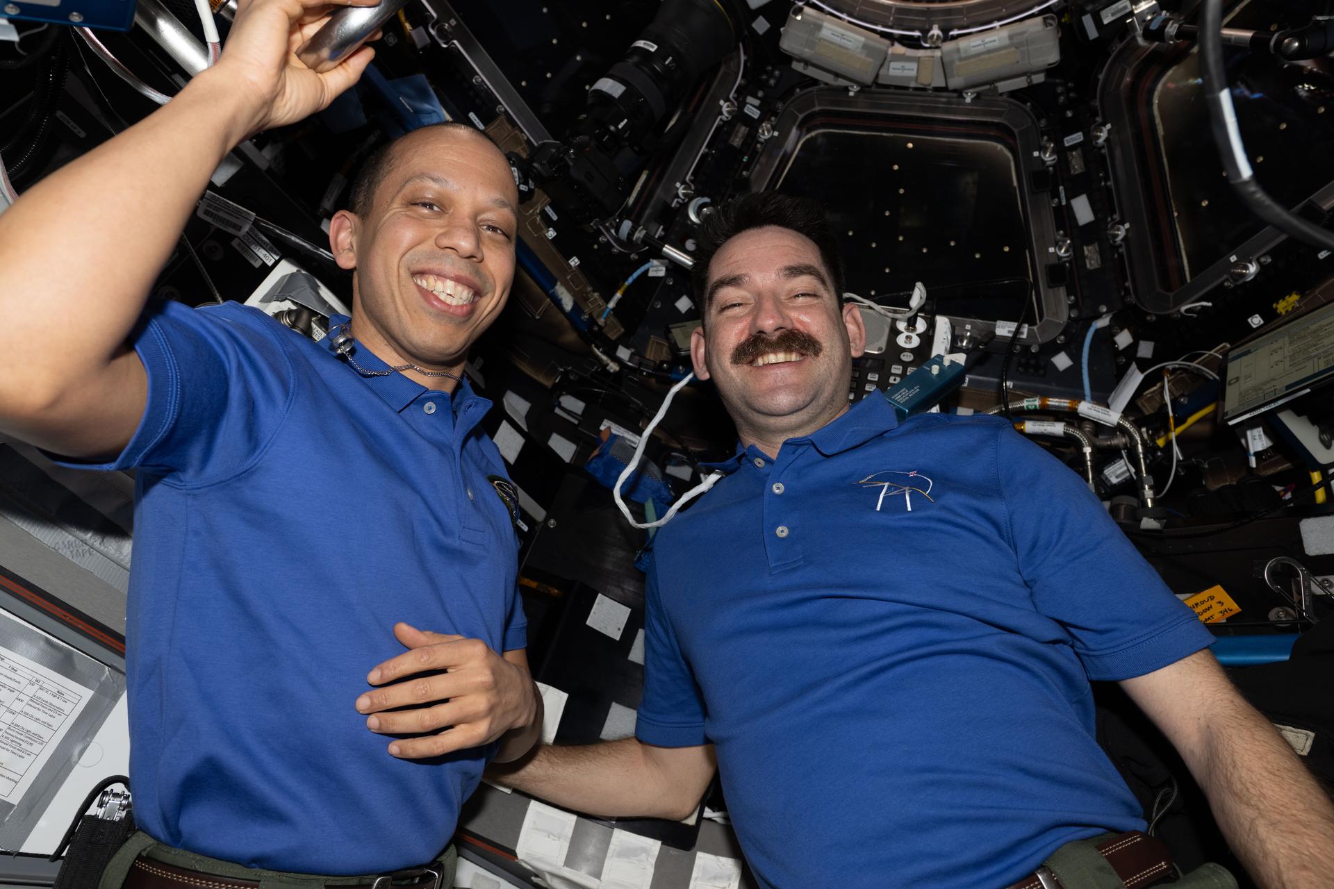 NASA astronauts (from left) Chris Williams and Jack Hathaway, both Expedition 74 flight engineers, pose for a portrait inside the cupola during a break in their procedures as Northrop Grumman's Cygnus XL cargo spacecraft approached the International Space Station. Williams operated the Canadarm2 robotic arm from inside the cupola to capture Cygnus XL, while Hathaway monitored the spacecraft during its approach and rendezvous. Cygnus XL delivered more than 11,000 pounds of new science experiments, lab hardware, and crew supplies for the Expedition 74 crew.