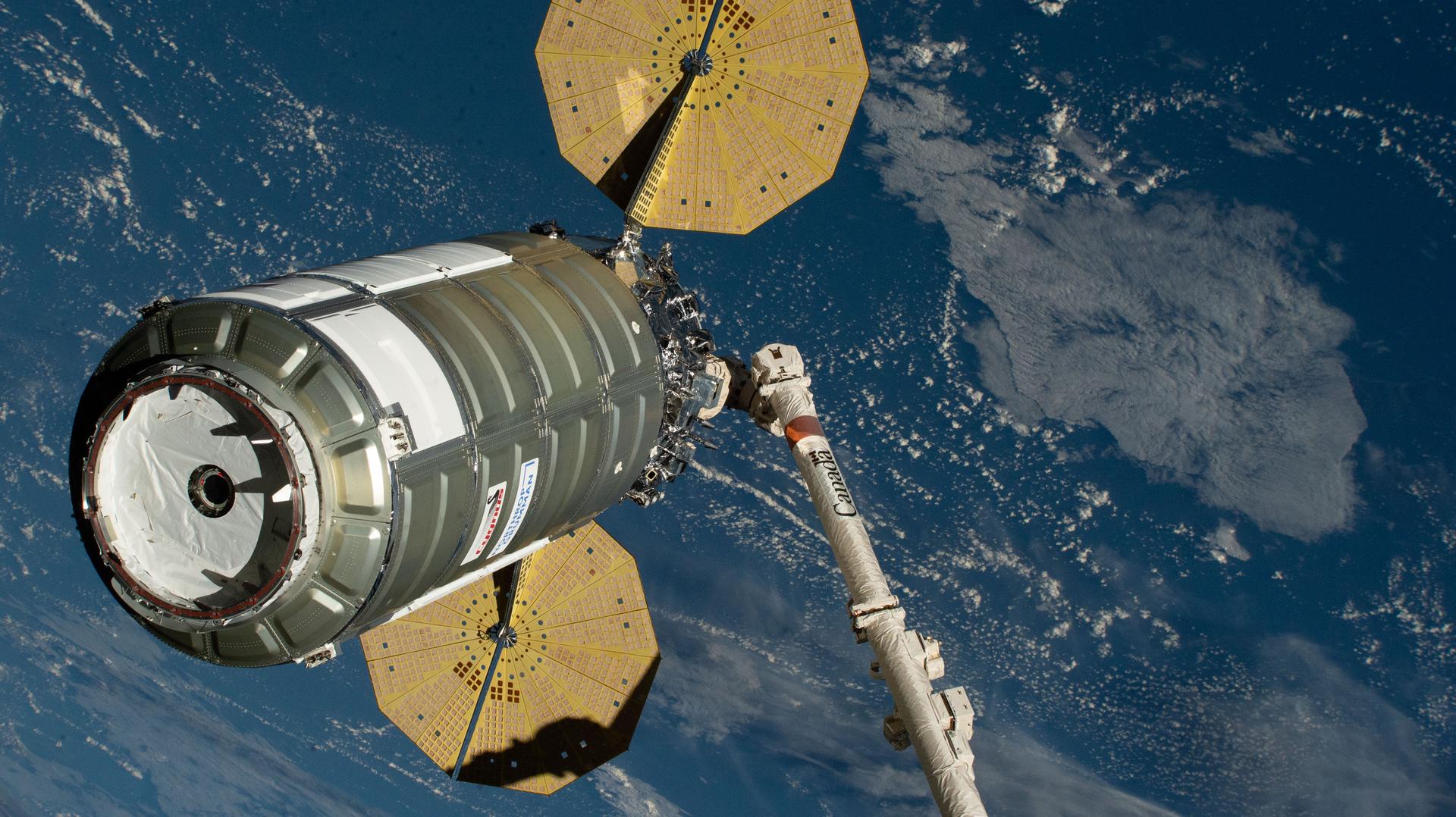 iss074e0459130 (April 13, 2026) --- Northrop Grumman's Cygnus XL cargo spacecraft is held in the grips of the Canadarm2 robotic arm as it is maneuvered toward the International Space Station’s Unity module for installation. Cygnus XL delivered more than 11,000 pounds of new science experiments, lab hardware, and crew supplies for the Expedition 74 crew. Credit: NASA