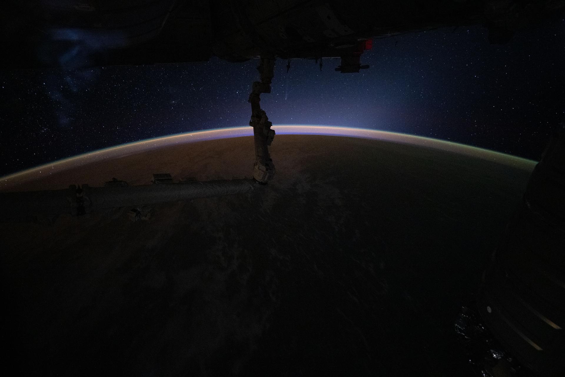 iss074e0480485 (April 17, 2026) --- This celestial image, taken moments before an orbital sunrise, reveals more than an airglow crowning Earth’s horizon—it also captures Comet C/2025 R3 (PANSTARRS) and its faint vertical tail (top center) at a distance of about 50 million miles from our planet. The International Space Station was orbiting 259 miles above the Pacific Ocean at approximately 3:50 a.m. local time when this photograph was taken. Credit: NASA/Chris Williams