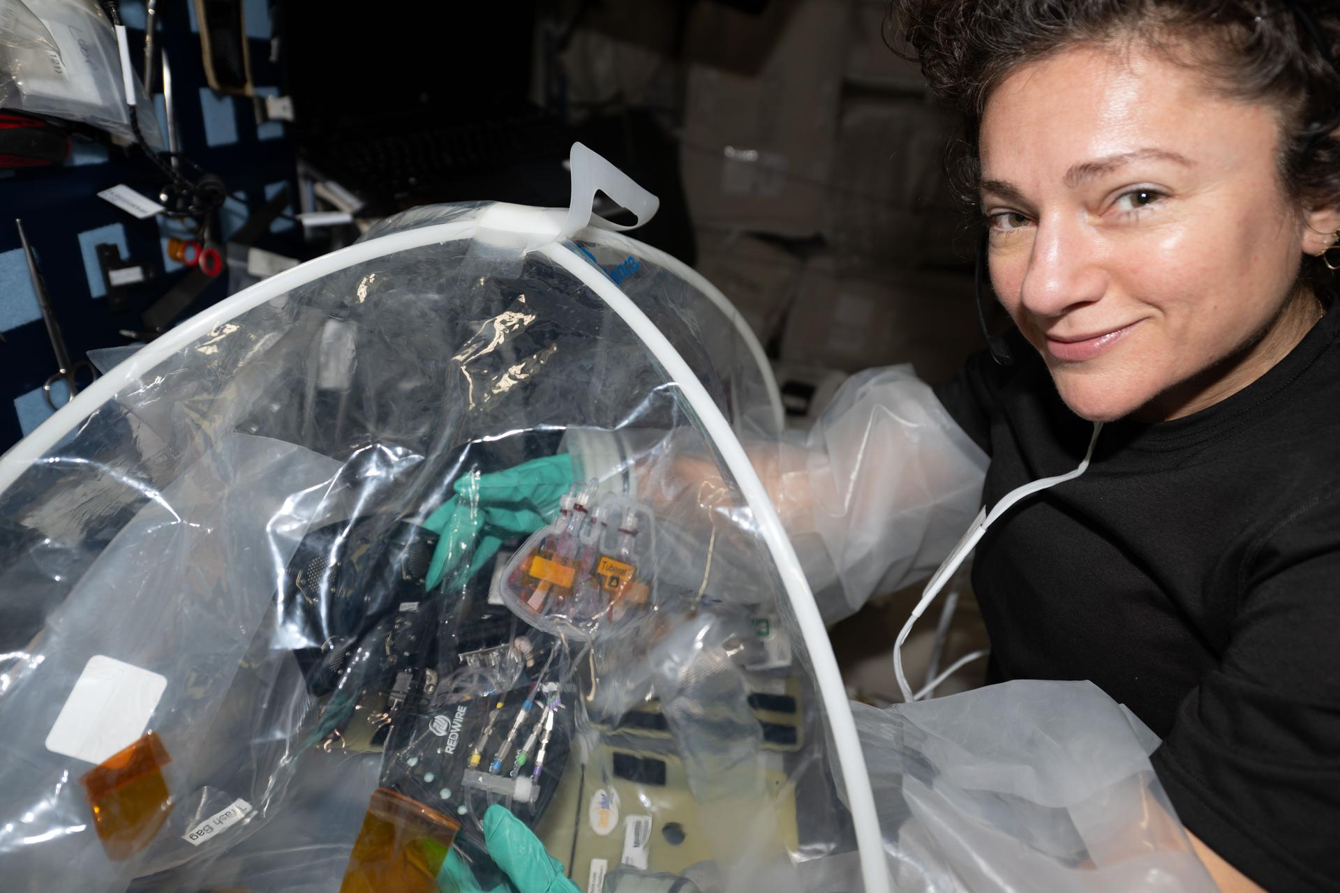 iss074e0490661 (April 16, 2026) --- NASA astronaut and Expedition 74 flight engineer Jessica Meir configures research hardware inside a portable glovebag for a biotechnology investigation exploring how bacteria affect heart tissue in the microgravity environment. Results from the MVP (Multi-use Variable-g Platform) Cell-09 experiment could lead to advanced methods for preventing or treating heart damage in humans living on and off the Earth. Credit: ESA/Sophie Adenot