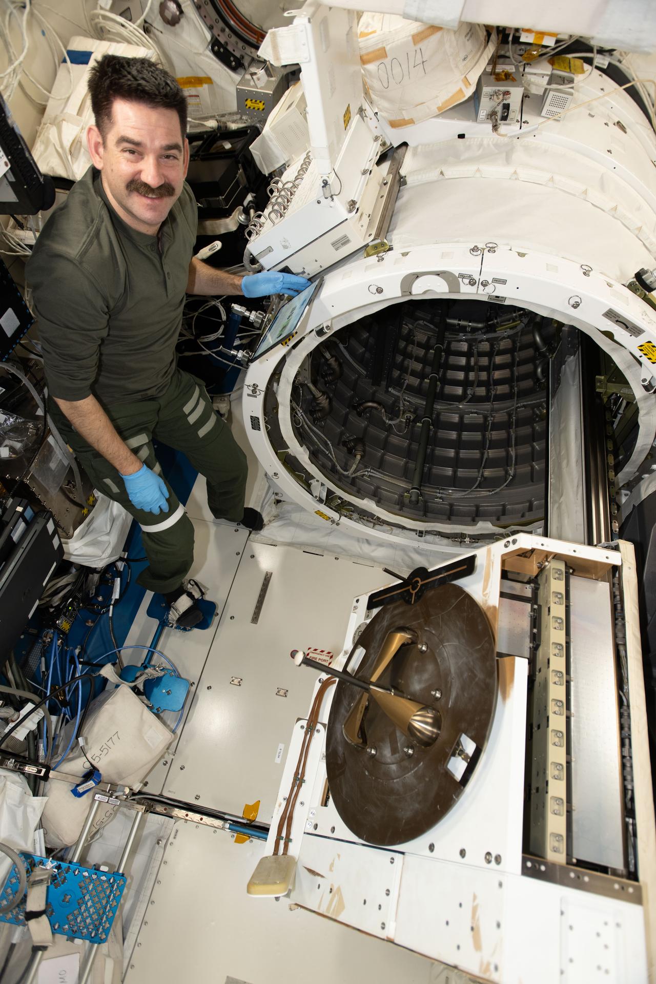 iss074e0491605 (April 20, 2026) --- NASA astronaut and Expedition 74 flight engineer Jack Hathaway installs the NanoRacks External Platform—carrying three scientific payloads—inside the Kibo laboratory module’s airlock for placement outside in the vacuum of space. The payloads will test ultra‑high‑resolution hyperspectral imagery, measure radio signals passing through Earth’s ionosphere, and help doctors identify space‑sensitive proteins while evaluating mobility and neuromuscular health therapies. Credit: NASA/Chris Williams