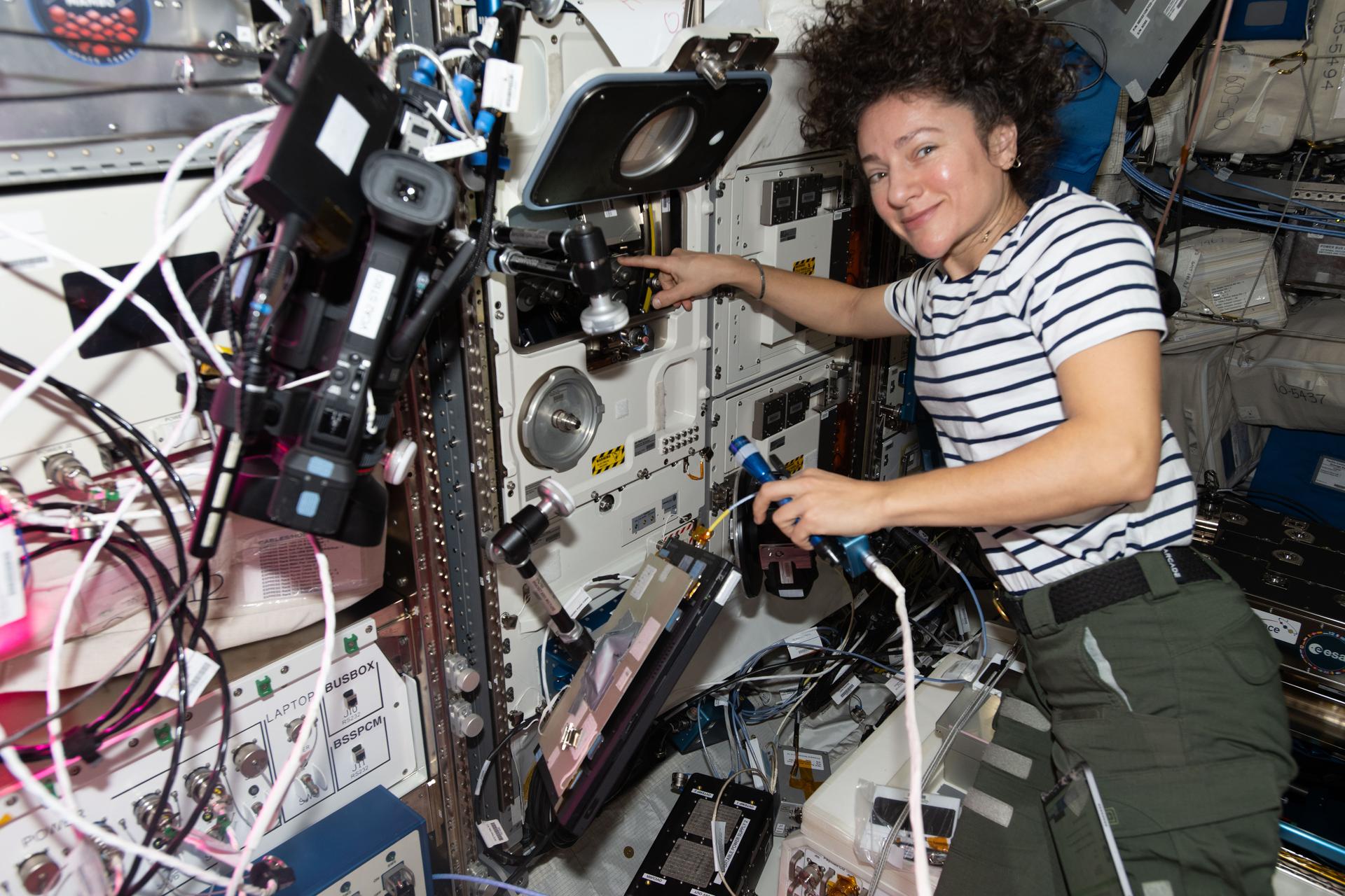 iss074e0503710 (April 22, 2026) --- NASA astronaut and Expedition 74 flight engineer Jessica Meir works inside the International Space Station’s Columbus laboratory module swapping scientific hardware inside the BioLab research incubator. Meir was supporting the Lux in Space investigation that observes how DNA damaged by space radiation repairs itself. Credit: NASA/Jack Hathaway