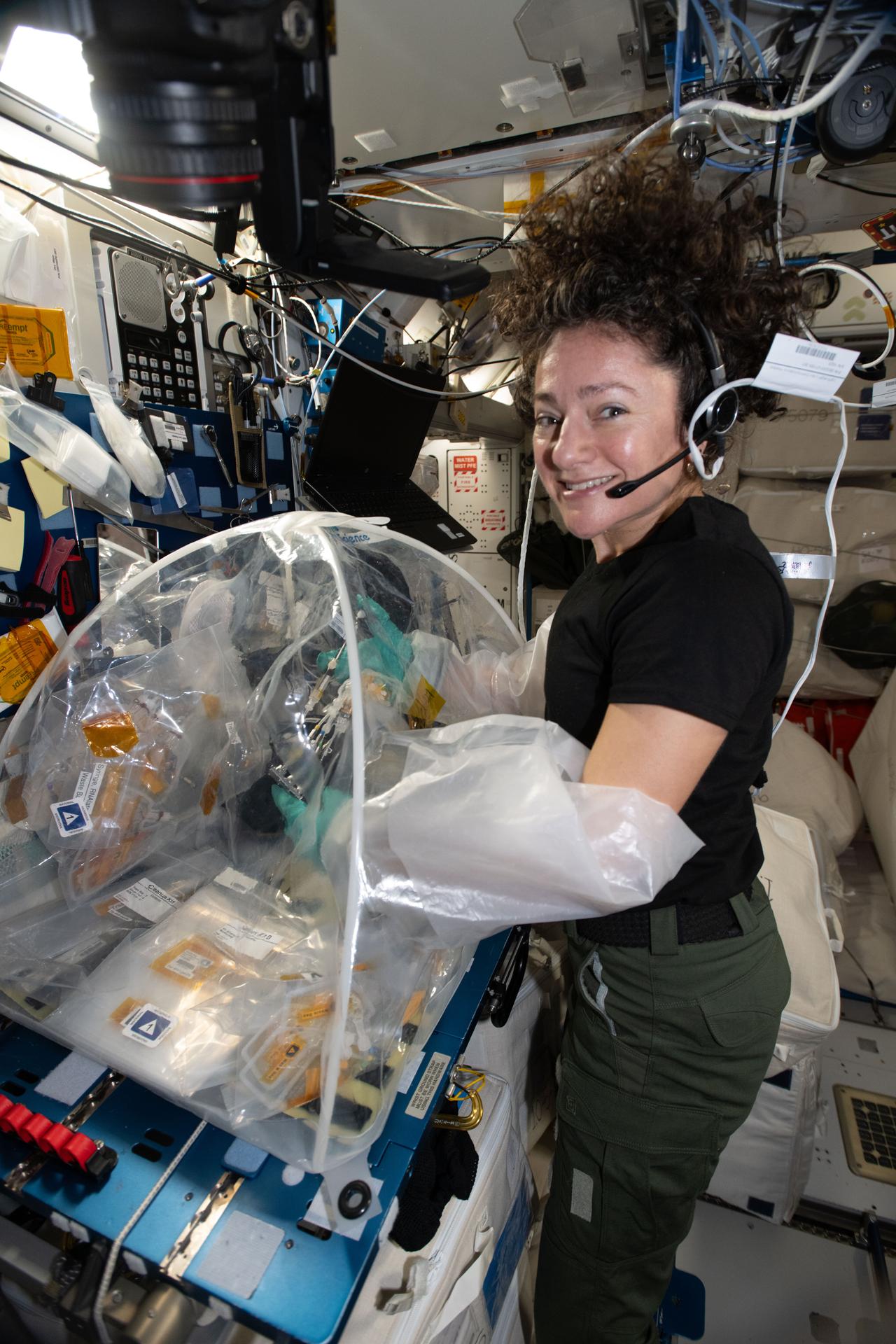iss074e0518242 (April 23, 2026) --- NASA astronaut and Expedition 74 flight engineer Jessica Meir processes samples of heart stem cells and bacteria that cause pneumonia using a portable glovebag inside the International Space Station's Harmony module. Research in microgravity may give doctors a clearer understanding of how infectious disease processes damage heart tissue at the cellular and molecular level. These insights could lead to advanced treatments for heart conditions both on Earth and in space. Credit: NASA/Chris Williams