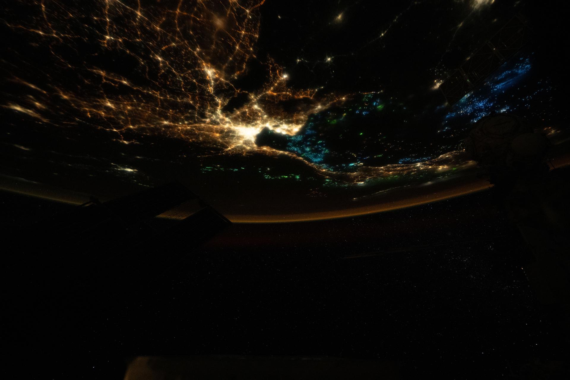 The blue lights of fishing boats dot the Gulf of Thailand contrasting with the city lights of Bangkok and its surrounding suburbs across the southeast Asian nation. The lights attract and illuminate plankton and small fish, luring squid toward the boats’ fishing nets. This photograph taken at approximately 1:49 a.m. local time from the International Space Station as it orbited 259 miles above Earth.