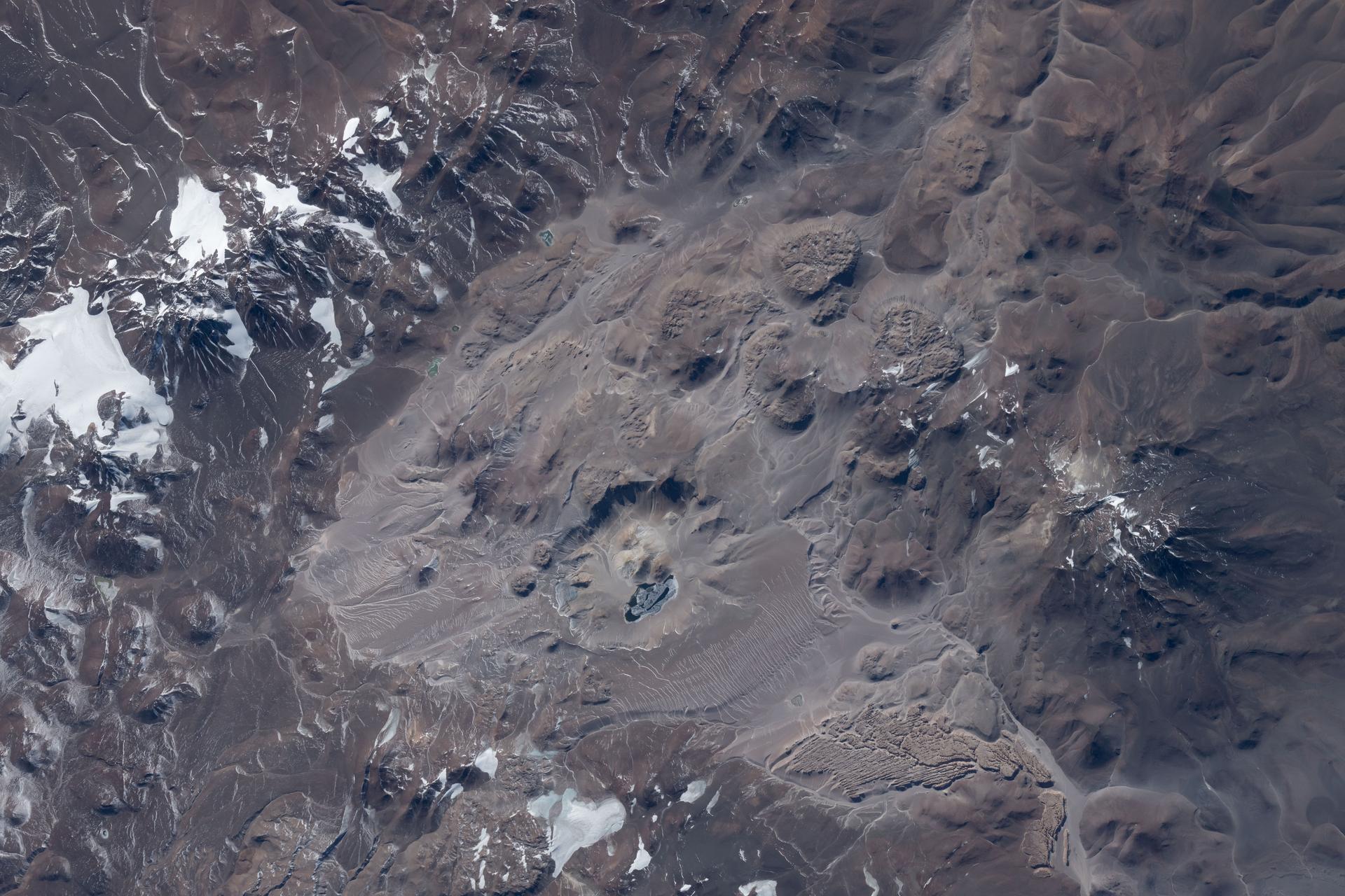 Argentina's Corona del Inca, a volcanic caldera formed about 520,000 years ago, also hosts the world’s highest navigable lake, whose relatively warm temperatures suggest ongoing hydrothermal activity. The International Space Station was orbiting 269 miles above the Andes Mountains when this photograph was taken.