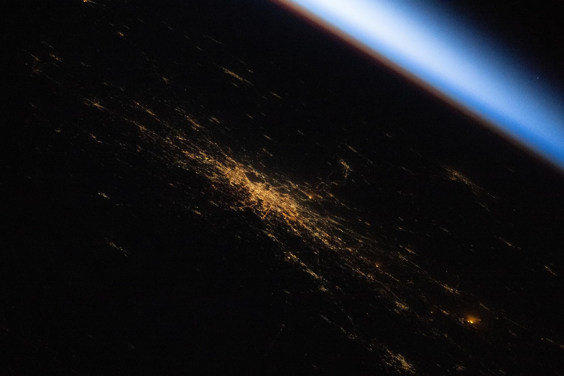 This oblique view of Moscow, Russia, was photographed at approximately 1:56 a.m. local time from the International Space Station as it soared 263 miles above Europe into an orbital sunrise. Moscow’s sodium‑vapor streetlights create an amber hue, revealing the city’s web‑like structure in this nighttime view.