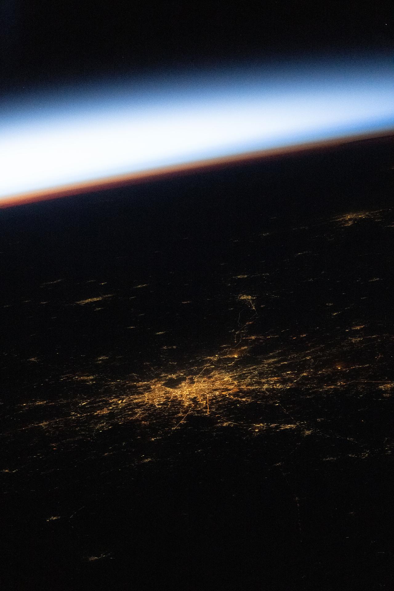 This oblique view of Moscow, Russia, was photographed at approximately 1:56 a.m. local time from the International Space Station as it soared 263 miles above Europe into an orbital sunrise. Moscow’s sodium‑vapor streetlights create an amber hue, revealing the city’s web‑like structure in this nighttime view.