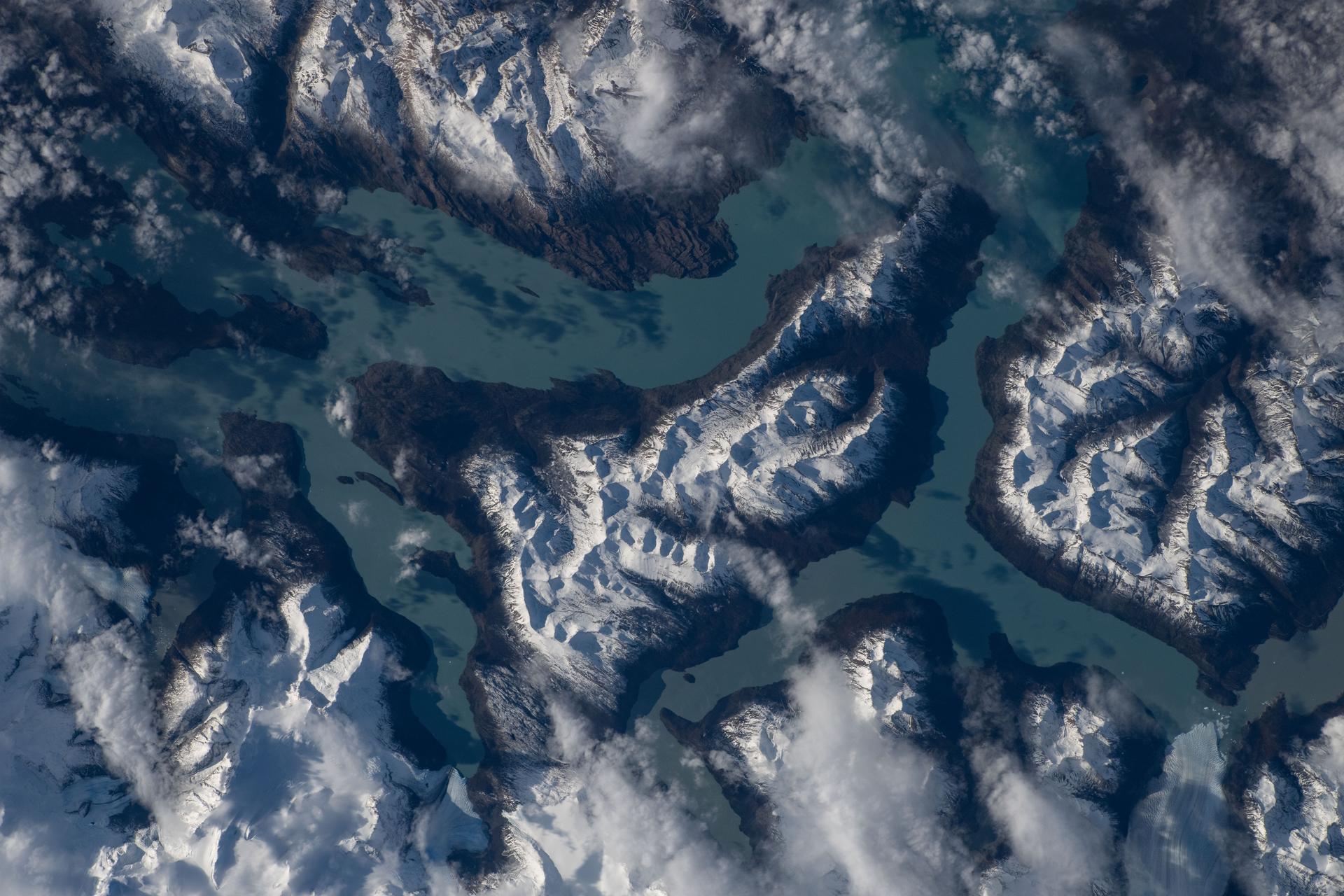 Turquoise-blue waters of Lake Argentino are surrounded by the snow-capped Andes Mountains in Los Glaciares National Park in Argentina's Santa Cruz Province. Multiple active glaciers feed the lake with their finely ground glacial sediment giving the lake its striking turquoise‑blue color. The International Space Station was orbiting 269 miles above South America's Patagonia region at the time of this photograph.