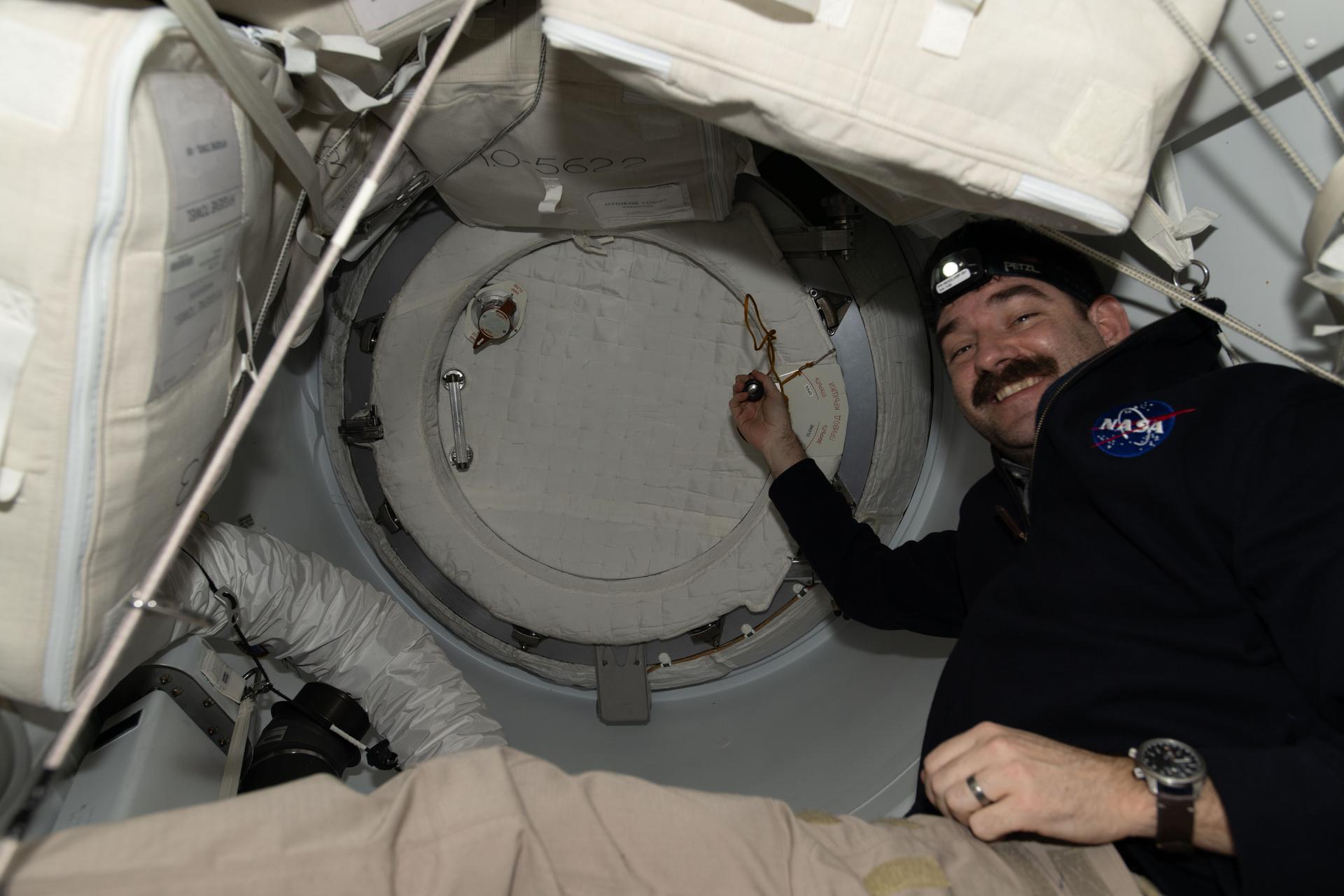 NASA astronaut and Expedition 74 flight engineer Jack Hathaway is pictured inside the vestibule between the SpaceX Dragon cargo spacecraft and the International Space Station’s forward port on the Harmony module. Moments later, Hathaway would open the Dragon’s hatch and begin unloading nearly 6,500 pounds of food, supplies, and equipment for the Expedition 74 crew.
