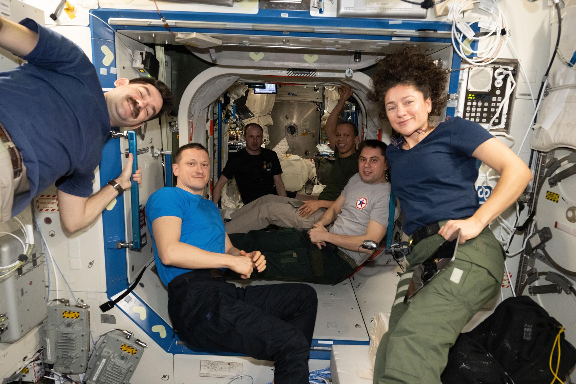 Six of the seven Expedition 74 crew members pose for a portrait together aboard the International Space Station. From left are, NASA astronaut Jack Hathaway, Roscosmos cosmonauts Sergey Kud‑Sverchkov and Sergey Mikaev, NASA astronaut Chris Williams, Roscosmos cosmonaut Andrey Fedyaev, and NASA astronaut Jessica Meir. The crew was checking out new hatch‑seal covers that were installed earlier in the day to protect the seals from damage and stains. ESA (European Space Agency) astronaut and Expedition 74 flight engineer Sophie Adenot is out of frame.