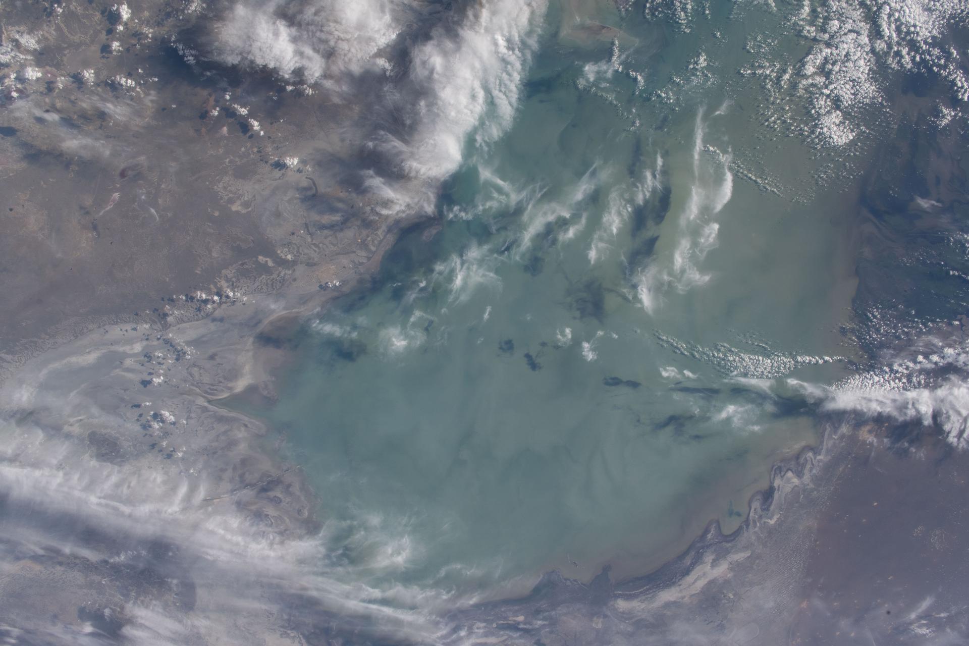 The northern part of the Caspian Sea, bordered by Kazakhstan, is fresher than the southern portion, which is much saltier due to the lack of an ocean outlet and increased evaporation that contributes to its salinity. Freshwater from the Volga, Ural, and Kura rivers feeds the northern region, diluting its salinity. The International Space Station was orbiting 260 miles above Central Asia when this photograph was taken.