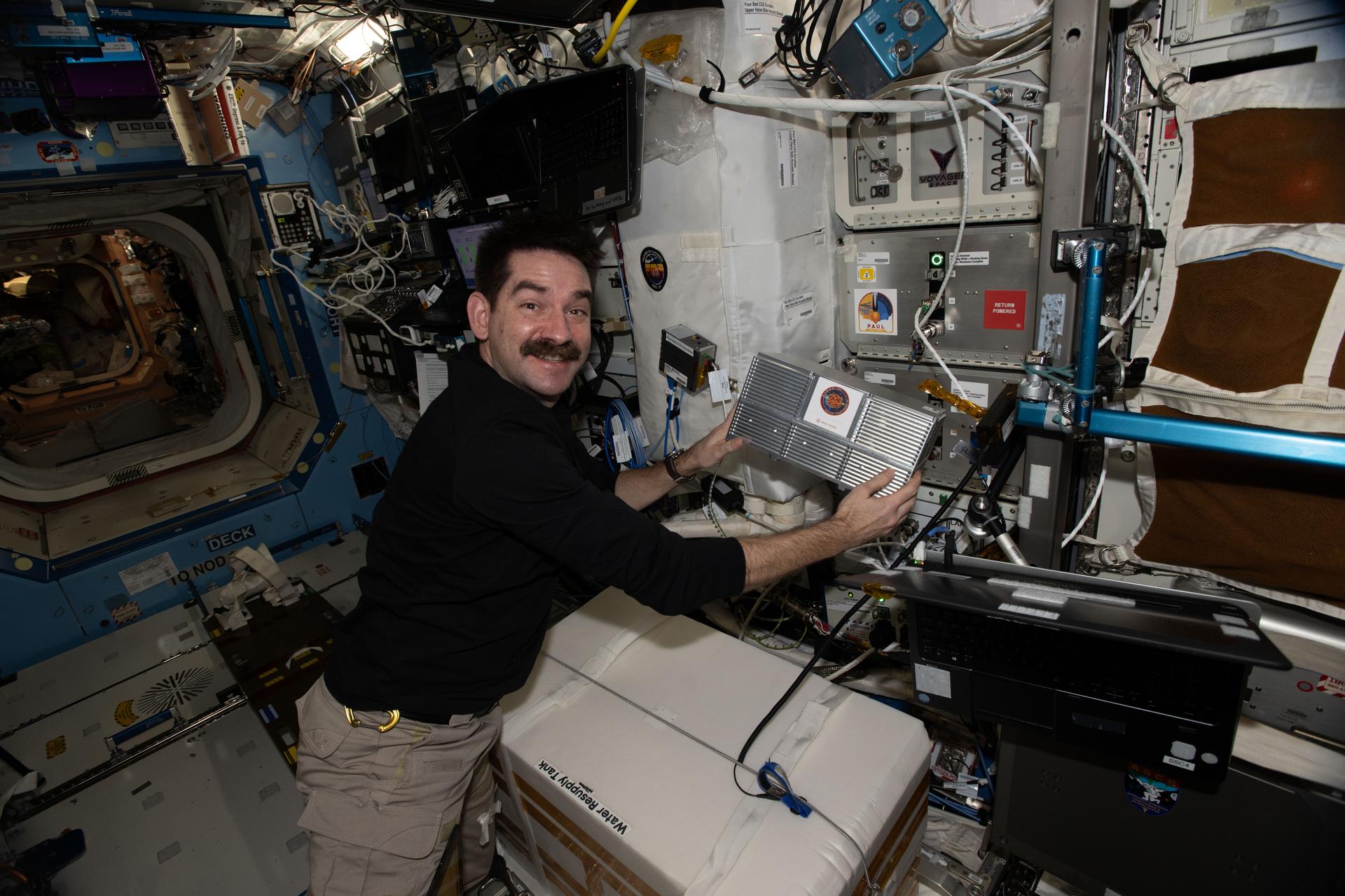 iss074e0603170 (May 19, 2026) --- NASA astronaut and Expedition 74 flight engineer Jack Hathaway installs research hardware inside a Powered Ascent Utility Locker (PAUL) in the International Space Station’s Columbus laboratory module. The PAUL powers, maintains, and protects sensitive experiments launched to space aboard spacecraft such as the SpaceX Dragon. After arriving on the station, the locker is installed in an EXPRESS rack so the experiments can continue receiving power and support for ongoing research. Credit: NASA/Jack Hathaway