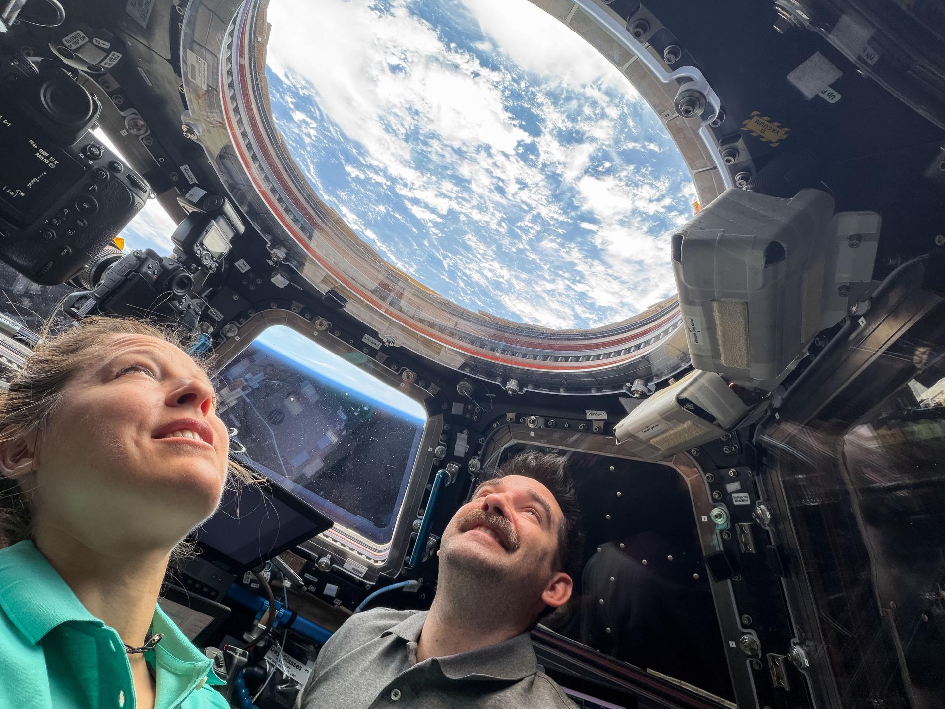 Astronauts Sophie Adenot of ESA (European Space Agency) and Jack Hathaway of NASA, both Expedition 74 flight engineers, look out a window in the cupola, monitoring the automated approach and docking of the SpaceX Dragon cargo spacecraft to the International Space Station. The orbital outpost was soaring 259 miles above the Indian Ocean just west of the Maldives at the time of this photograph.