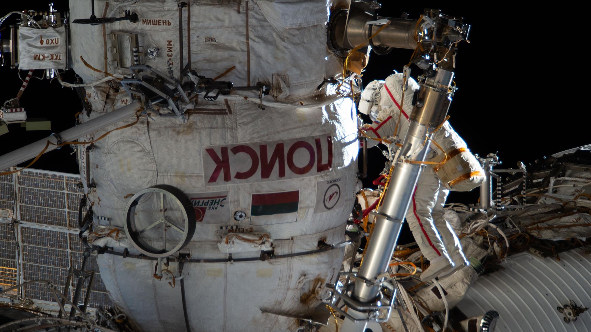 Roscosmos cosmonaut and Expedition 74 commander Sergey Kud-Sverchkov works outside the International Space Station in his Orlan spacesuit with red stripes. During the six-hour and five-minute spacewalk, Kud‑Sverchkov, along with Roscosmos cosmonaut Sergei Mikaev (out of frame), installed a solar radiation experiment and removed physics and microbiology research hardware from the orbital outpost.