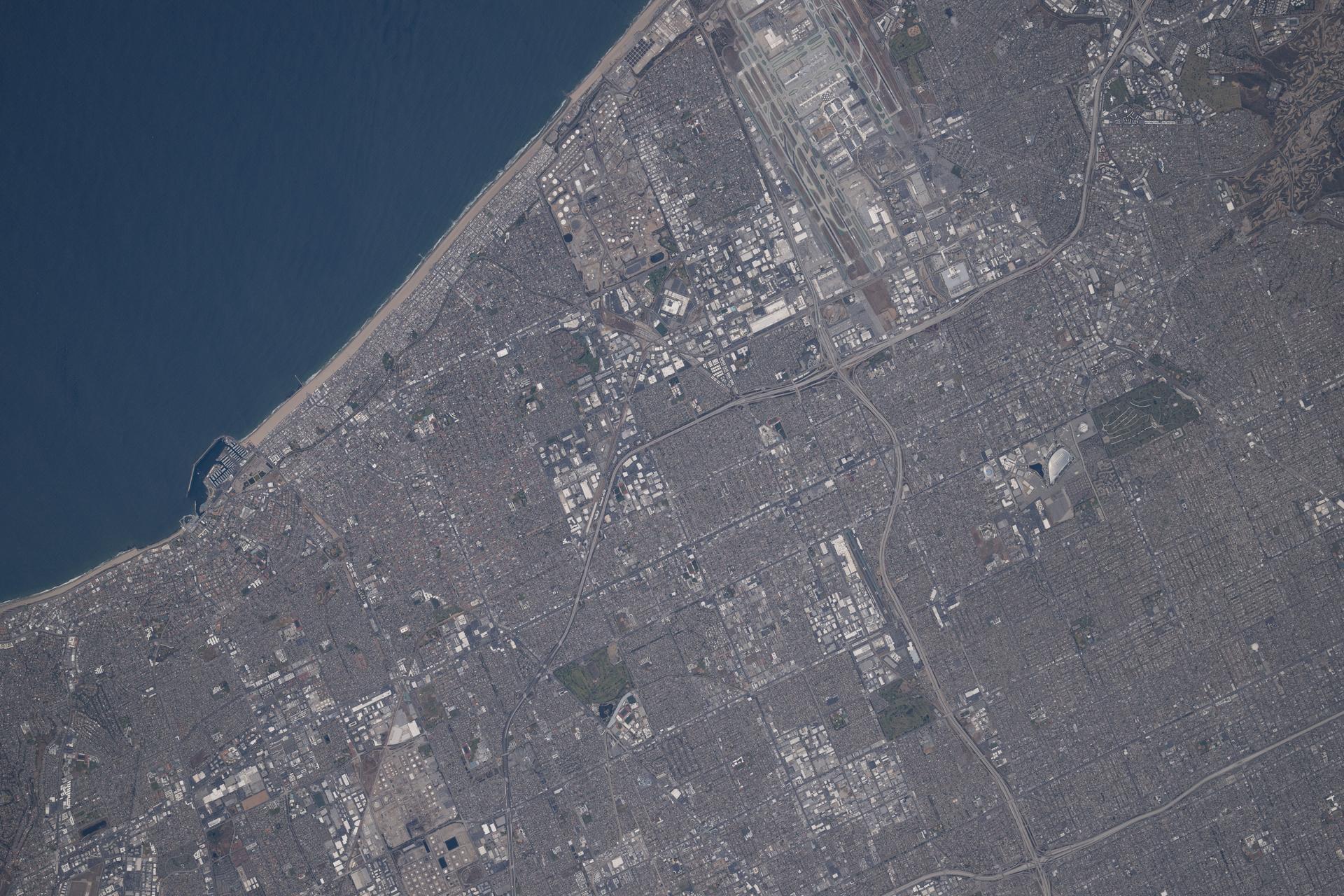 At the top, Los Angeles International Airport — the primary international gateway on the U.S. West Coast and the nation's fifth‑busiest airport — is pictured on Southern California's Pacific coastline from the International Space Station as it orbited 260 miles above the Golden State.