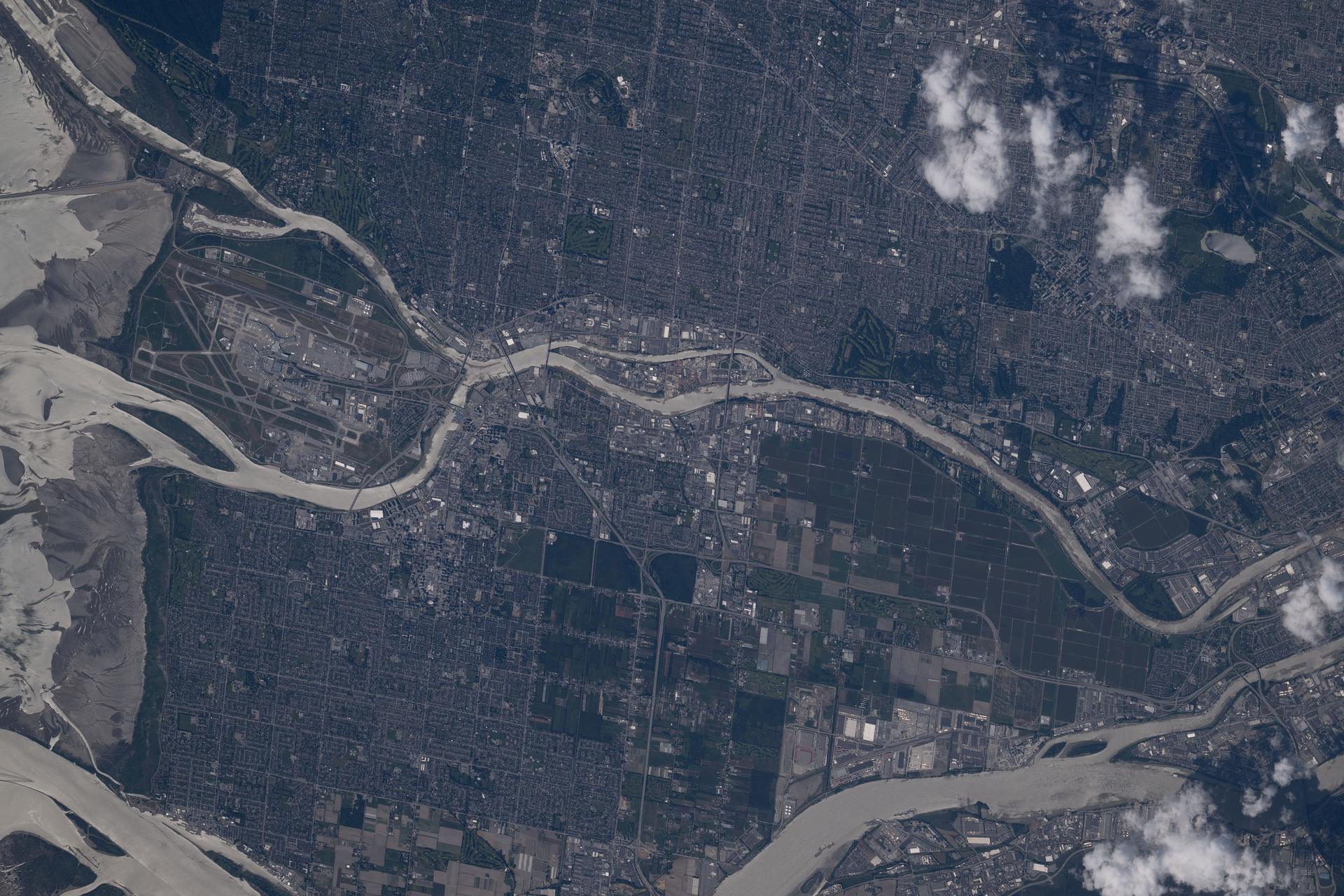 iss074e0623357 (May 30, 2026) --- Vancouver International Airport sits on Sea Island (left), where the Fraser River splits into its North and Middle Arms—a natural bifurcation—before emptying into the Strait of Georgia on Canada’s Pacific coast. The airport is the nation’s second busiest and lies just south of Vancouver, a metropolitan area of about 2.73 million people and 23 surrounding jurisdictions. Credit: NASA/Chris Williams