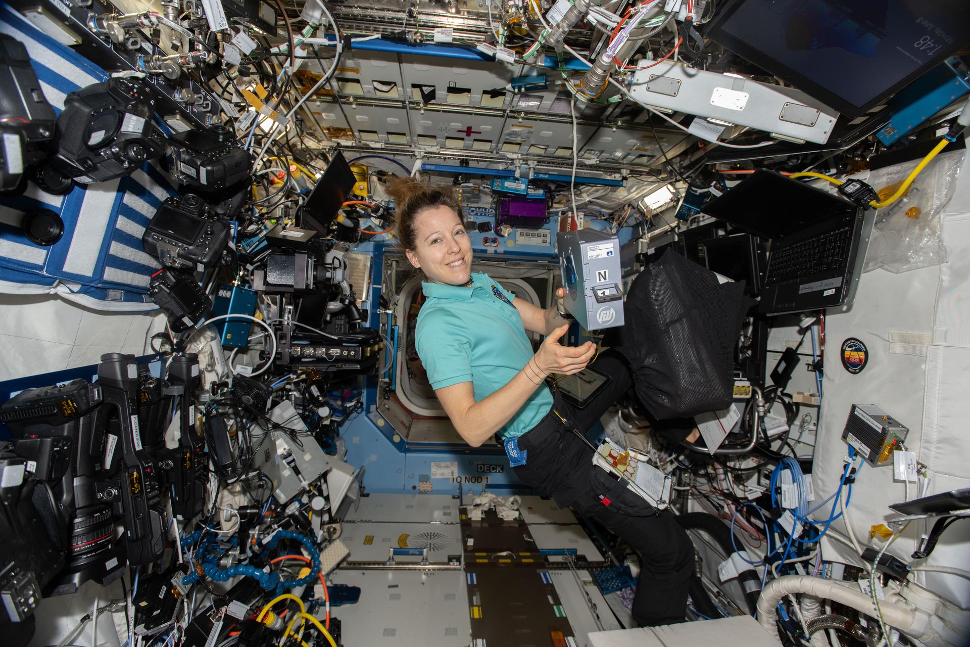 ESA (European Space Agency) astronaut and Expedition 74 flight engineer Sophie Adenot shows off an Advanced Space Experiment Sample Processor-4 research cassette being used aboard the International Space Station to study how weightlessness affects drug crystals, possibly leading to new pharmaceutical formulas.