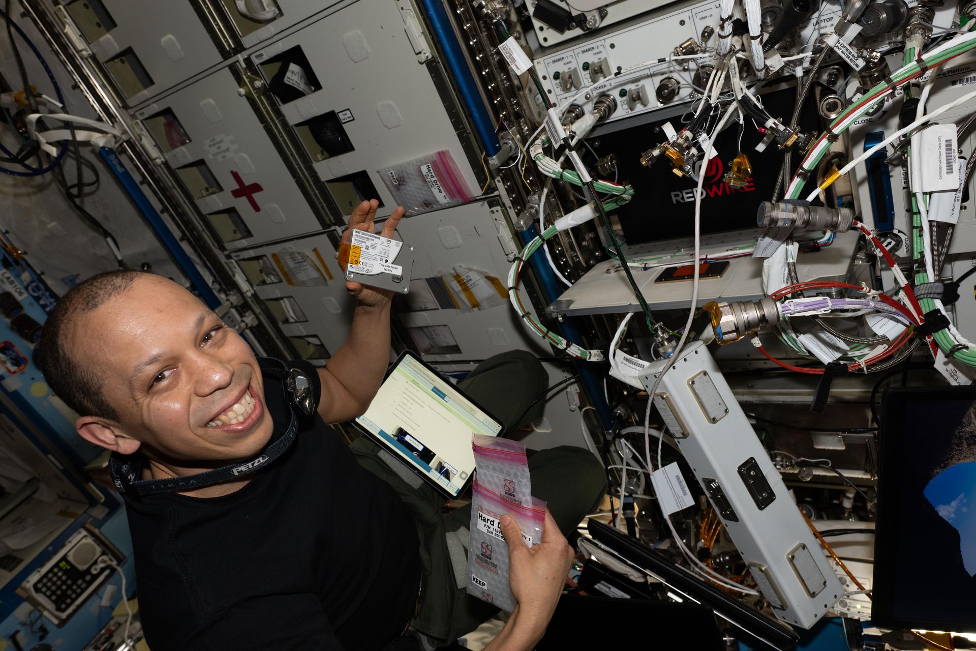 NASA astronaut and Expedition 74 flight engineer Chris Williams swaps hard drives inside the Advanced Space Experiment Processor-4, a research device that supports the processing of scientific samples, increasing the International Space Station's capacity for microgravity research.