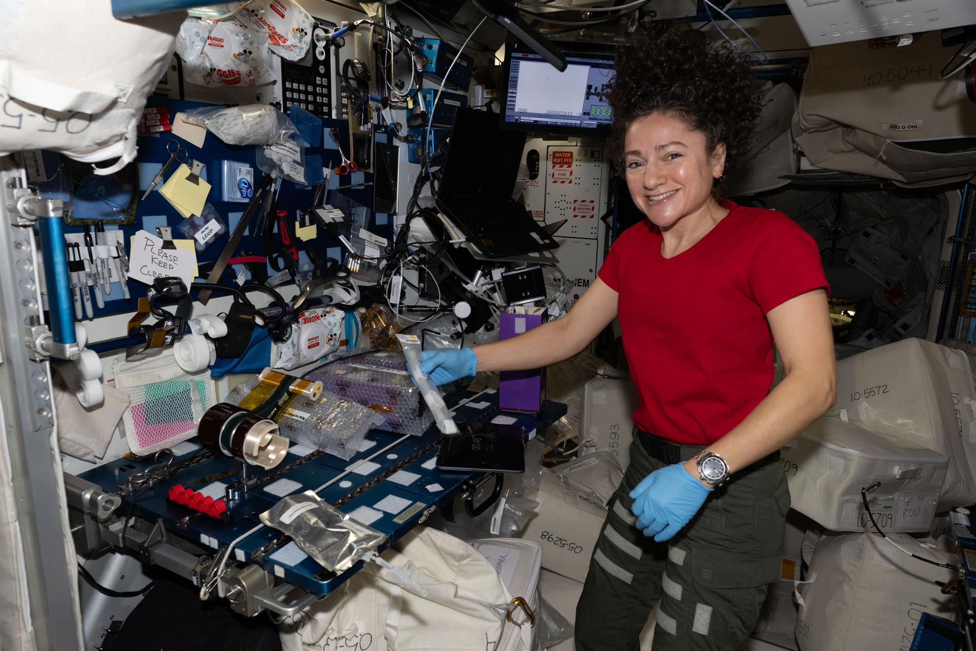 NASA astronaut and Expedition 74 flight engineer Jessica Meir activates tubes filled with microbial and botanical samples associated with a variety of student-designed experiments inside the International Space Station's Harmony module.