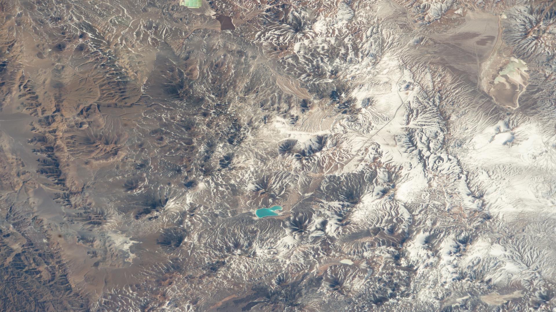 Laguna Verde (near the lower center) lies just south—with south oriented upward in this image—of Ojos del Salado, the highest active stratovolcano in the world at 22,615 feet (6,893 meters), located in Chile’s Atacama Region in the Andes. The International Space Station was orbiting 264 miles above the South American nation at the time of this photograph.