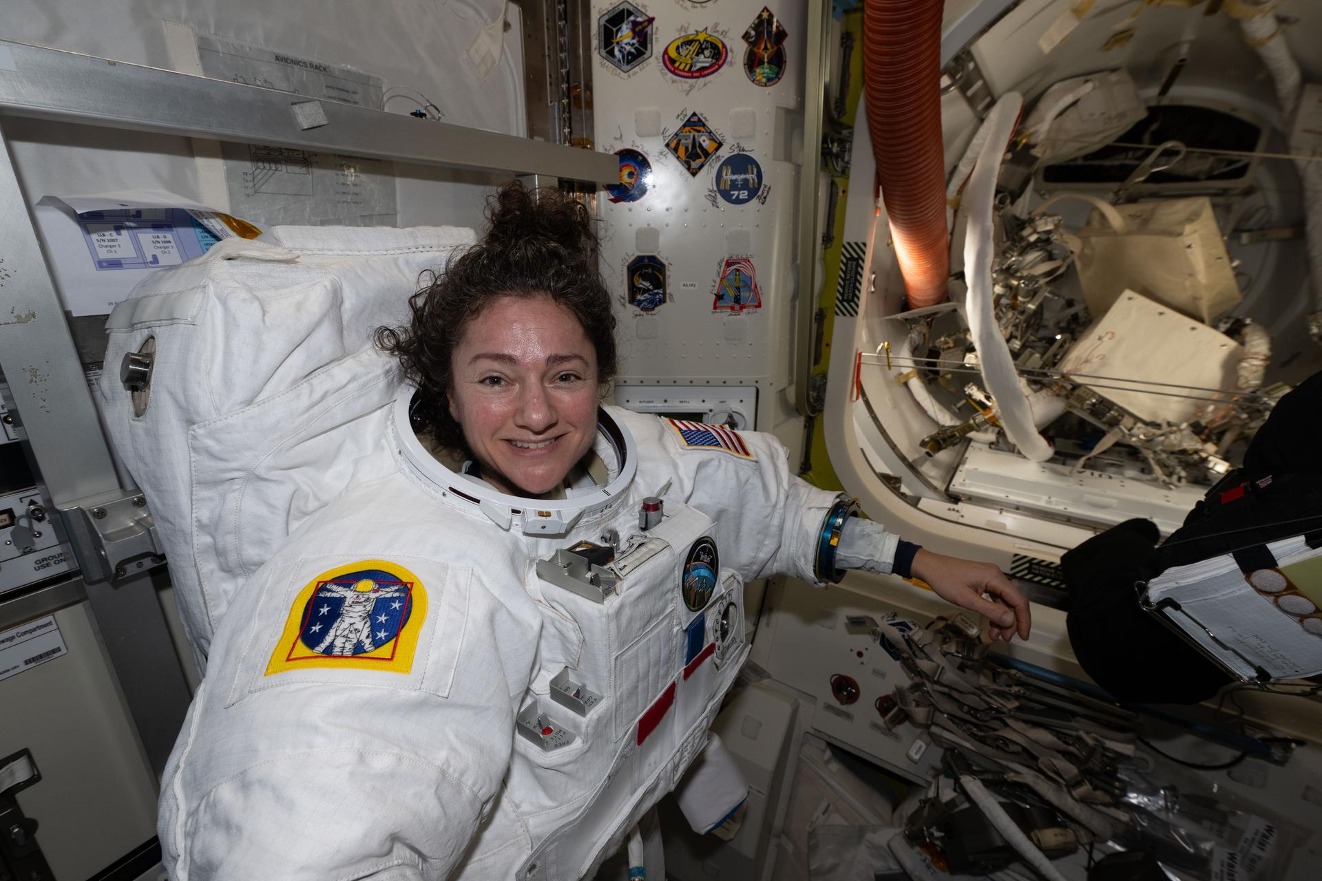 iss074e0760518 (June 23, 2026) --- NASA astronaut and Expedition 74 flight engineer Jessica Meir tries on her spacesuit, testing its comfort and mobility as well as its communications and life support systems inside the International Space Station’s Quest airlock. Meir was preparing for a spacewalk to replace a malfunctioning wrist joint on the Canadarm2 robotic arm, planned for June 30, 2026. Credit: NASA