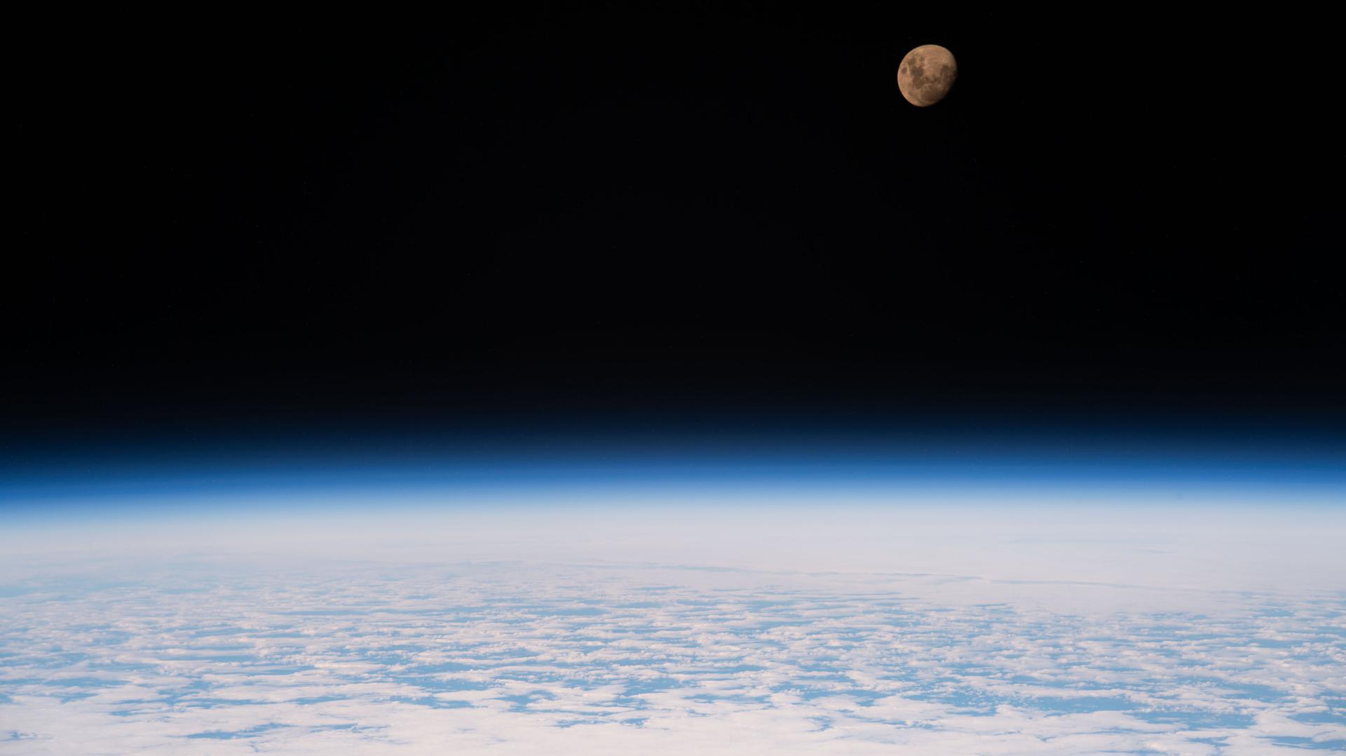The waxing gibbous Moon is pictured above Earth from the International Space Station as it orbited 264 miles above a partly cloudy Indian Ocean southeast of Madagascar.