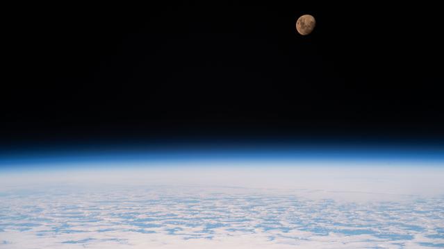 The waxing gibbous Moon is pictured above a partly cloudy Indian Ocean