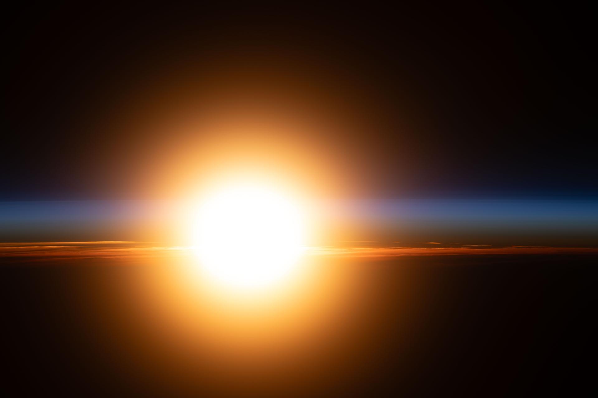 A bright orange sunburst illuminates Earth's atmosphere during an orbital sunrise in this photograph from the International Space Station as it orbited 264 miles above the Caucasus Mountains.