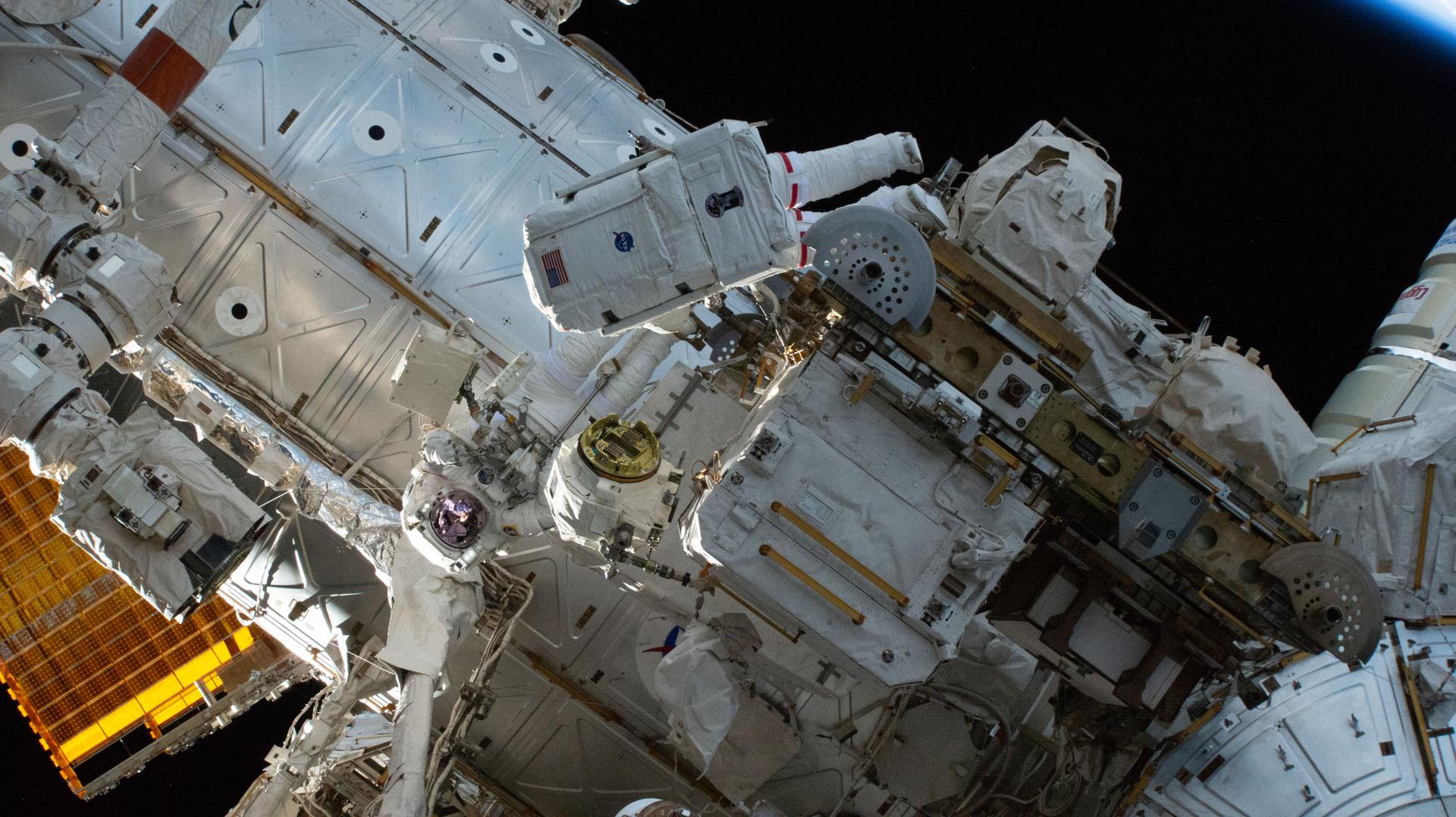 NASA astronauts (at center, from left) Jessica Meir and Chris Williams work outside the International Space Station during a seven-hour and 20-minute spacewalk to replace a malfunctioning wrist joint on the Canadarm2 robotic arm. This was the second spacewalk the duo performed together, Meir's fifth, and Williams' second.