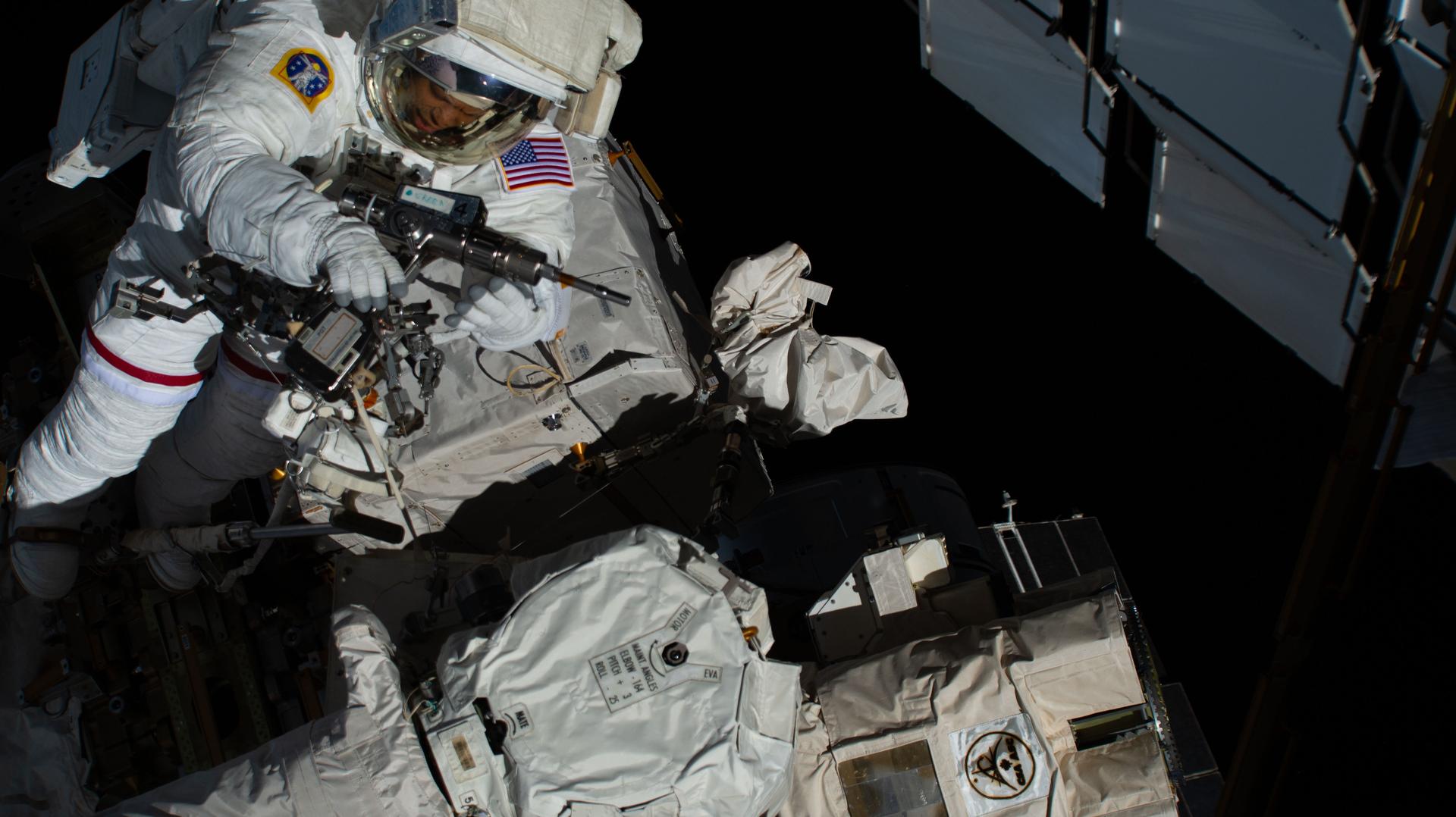 NASA astronaut and Expedition 74 flight engineer Chris Williams uses a pistol grip tool during a spacewalk to repair the malfunctioning wrist joint on the International Space Station's Canadarm2 robotic arm. Williams, along with NASA astronaut and Expedition 74 flight engineer Jessica Meir (out of frame), spent seven hours and 20 minutes in the vacuum of space during the maintenance spacewalk.