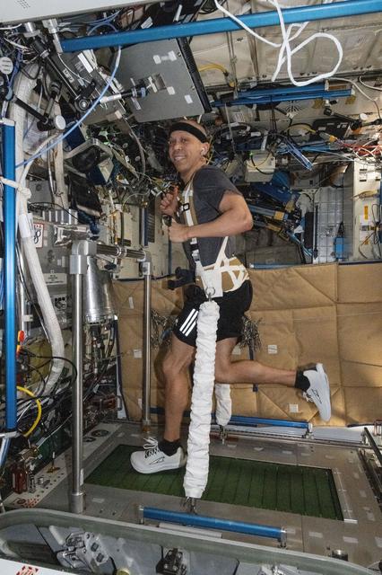 NASA astronaut Chris Williams jogs while strapped to the treadmill inside the International Space Station