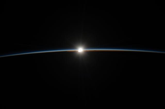 A diamond‑like orbital sunset, also known as a sun glint, illuminates Earth’s thin atmosphere
