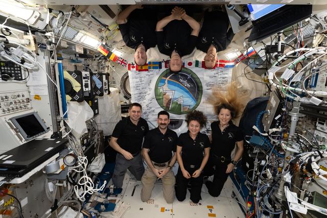The seven‑member Expedition 74 crew poses for a portrait inside the International Space Station’s Kibo laboratory module
