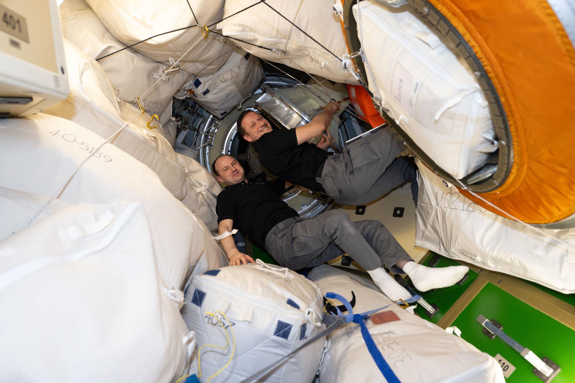 Expedition 74 flight engineer (from left) Sergei Mikaev and station commander Sergey Kud-Sverchkov, both from Roscosmos, open the hatch between the International Space Station's Prichal module and the Soyuz MS-29 spacecraft. Moments later, new station crew members Anil Menon of NASA and Pyotr Dubrov and Anna Kikina, both from Roscosmos, would exit the Soyuz MS-29 and enter Prichal beginning an eight-and-a-half-month space research mission.