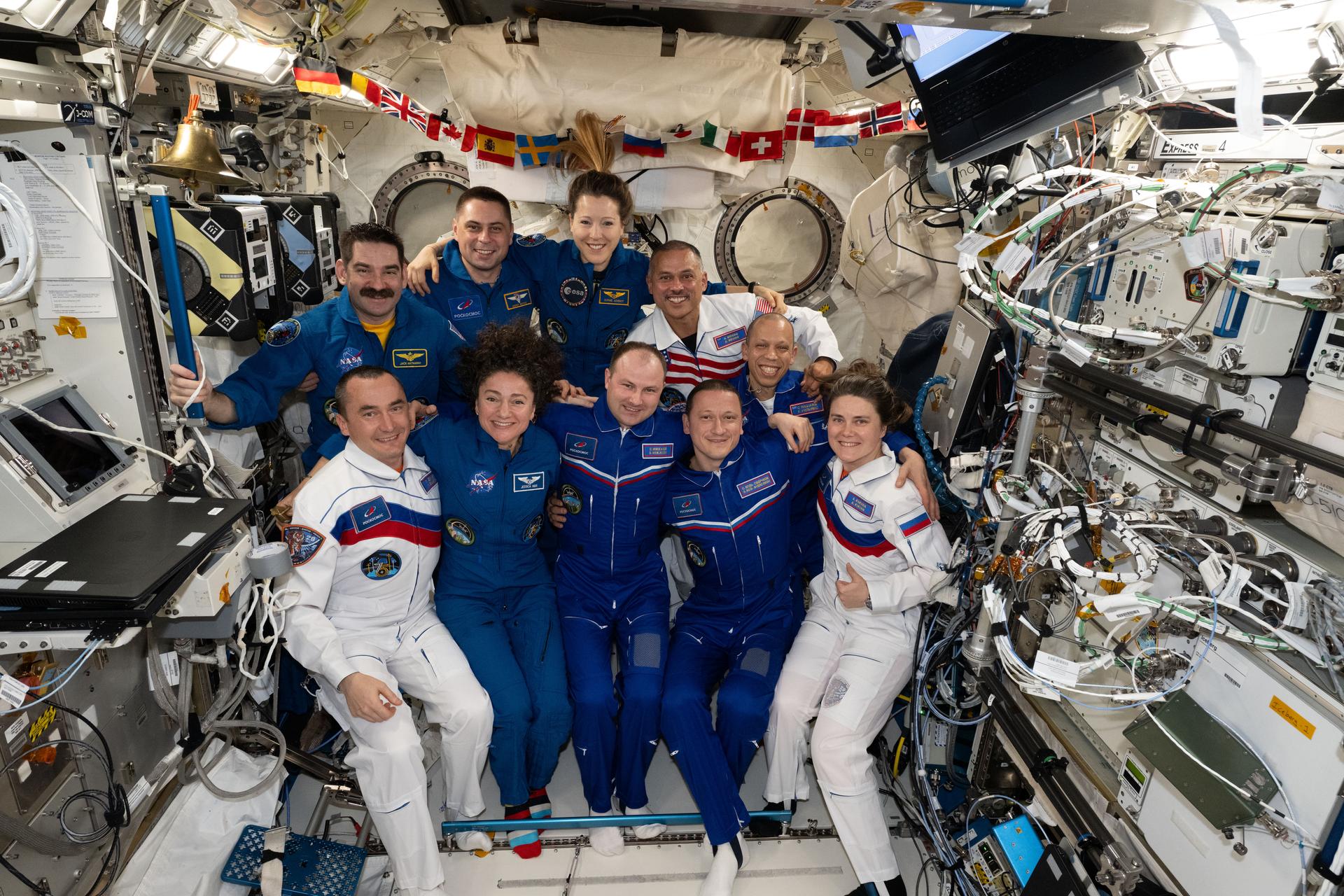The ten-member Expedition 74 crew poses for a portrait inside the International Space Station's Kibo laboratory module. In the front row, from left are, Roscosmos cosmonaut Pyotr Dubrov; NASA astronaut Jessica Meir; and Roscosmos cosmonauts Sergei Mikaev, Sergey Kud-Sverchkov, and Anna Kikina. In the back are NASA astronaut Jack Hathaway; Roscosmos cosmonauts Andrey Fedyaev; ESA (European Space Agency) astronaut Sophie Adenot; and NASA astronauts Anil Menon and Chris Williams.