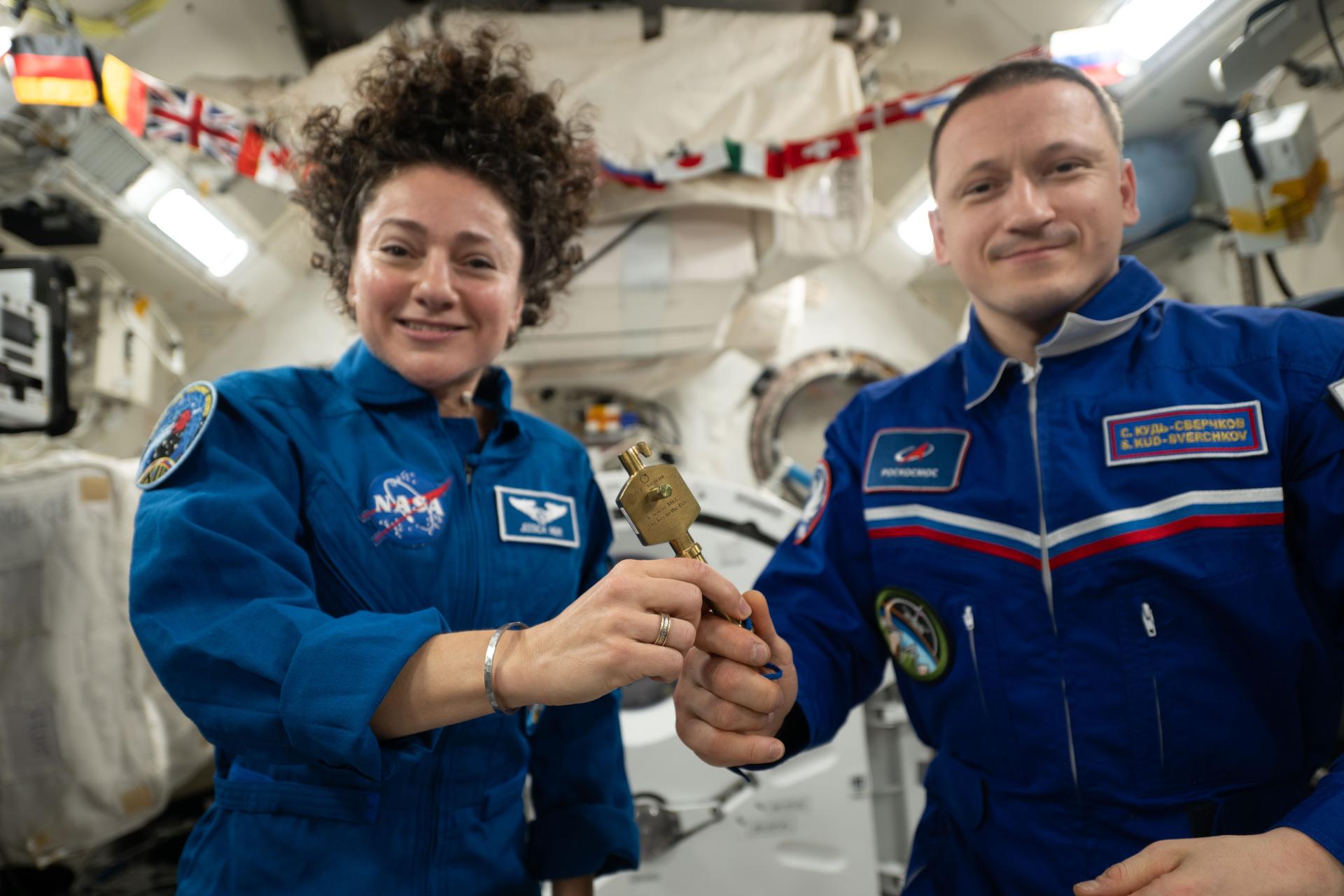 iss074e0835303 (July 25, 2026) --- NASA astronaut Jessica Meir accepts a ceremonial key from Roscosmos cosmonaut Sergey Kud‑Sverchkov, signifying the traditional change of command aboard the International Space Station. Meir is leading the Expedition 75 crew until the end of summer. Kud‑Sverchkov was commander of Expedition 74 before concluding his 241‑day mission the following day with NASA astronaut Chris Williams and Roscosmos cosmonaut Sergei Mikaev (both out of frame), parachuting to a landing in Kazakhstan aboard the Soyuz MS‑28 spacecraft. Credit: NASA/Anil Menon
