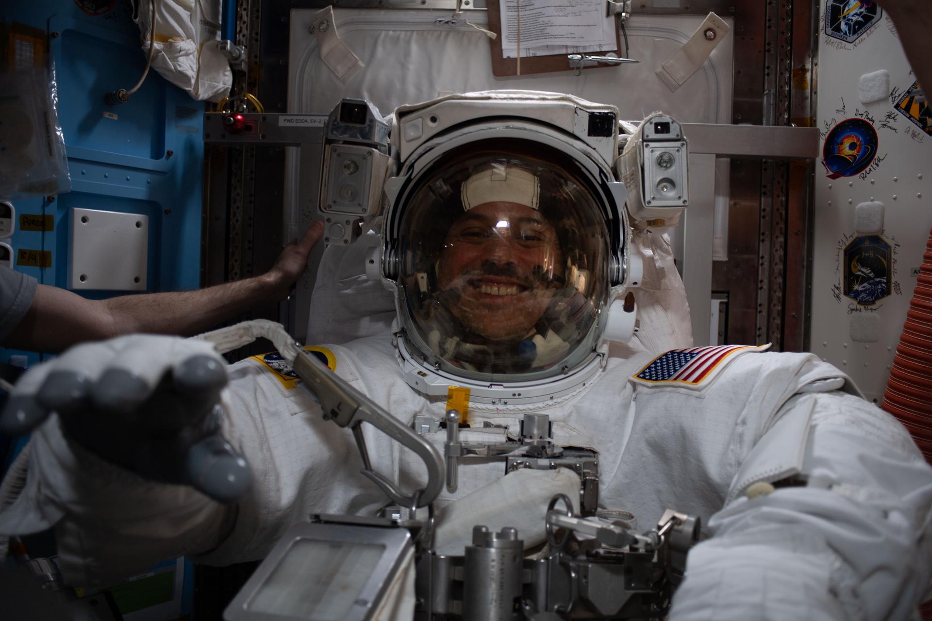iss075e0001976 (Aug. 4, 2026) --- NASA astronaut and Expedition 74 flight engineer Anil Menon is pictured inside the Quest airlock tryng on a spacesuit to verify its comfort, mobility, and functionality. Menon was conducting an on-orbit fit verification of the suit before conducting his first spacewalk outside of the International Space Station. Credit: NASA/Jessica Meir