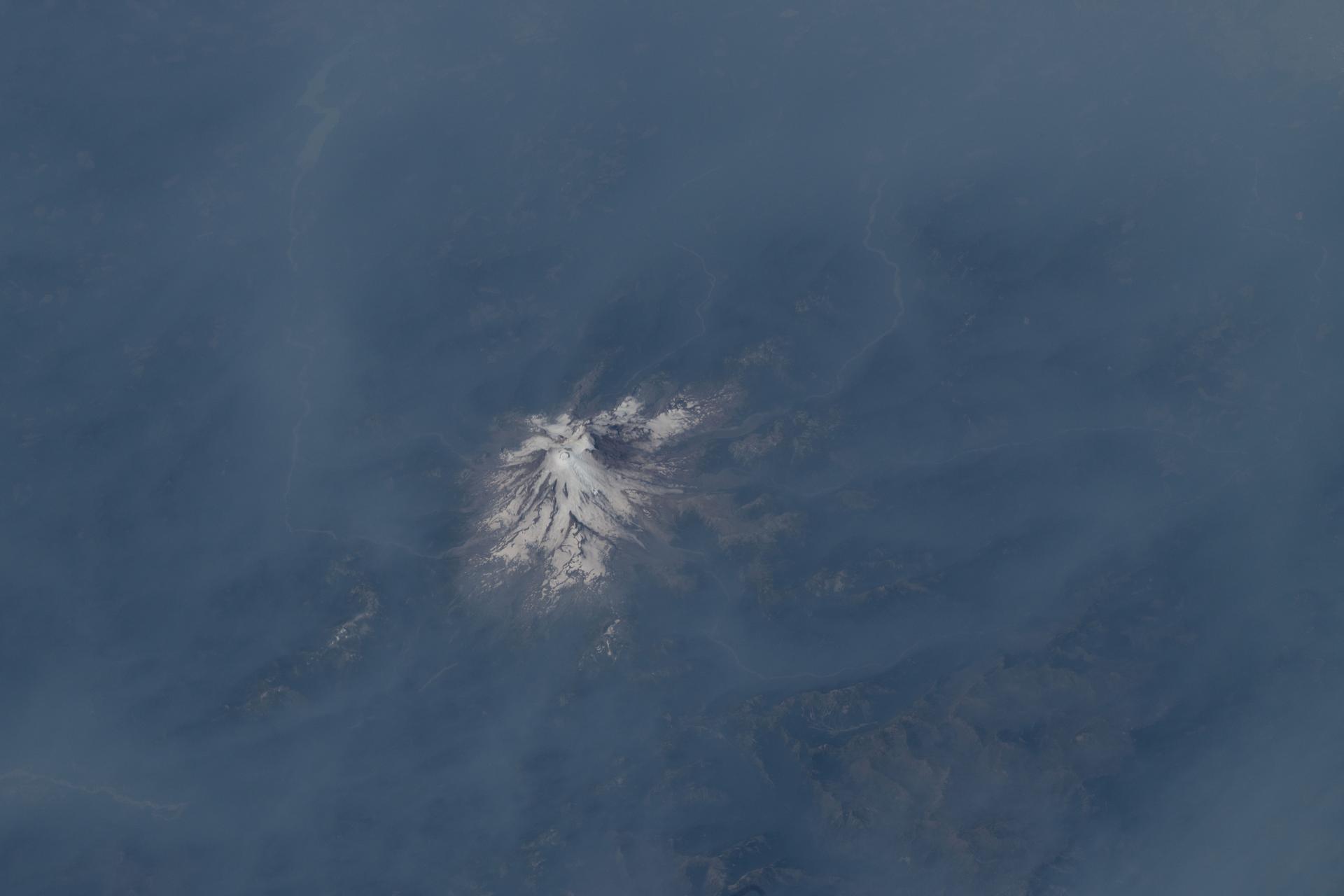 Washington state's Mount Rainier stands out above the hazy smoke emanating from wildfires throughout the United State's Pacific Northwest region. The International Space Station was orbiting 262 miles above the Evergreen State at the time of this photograph.