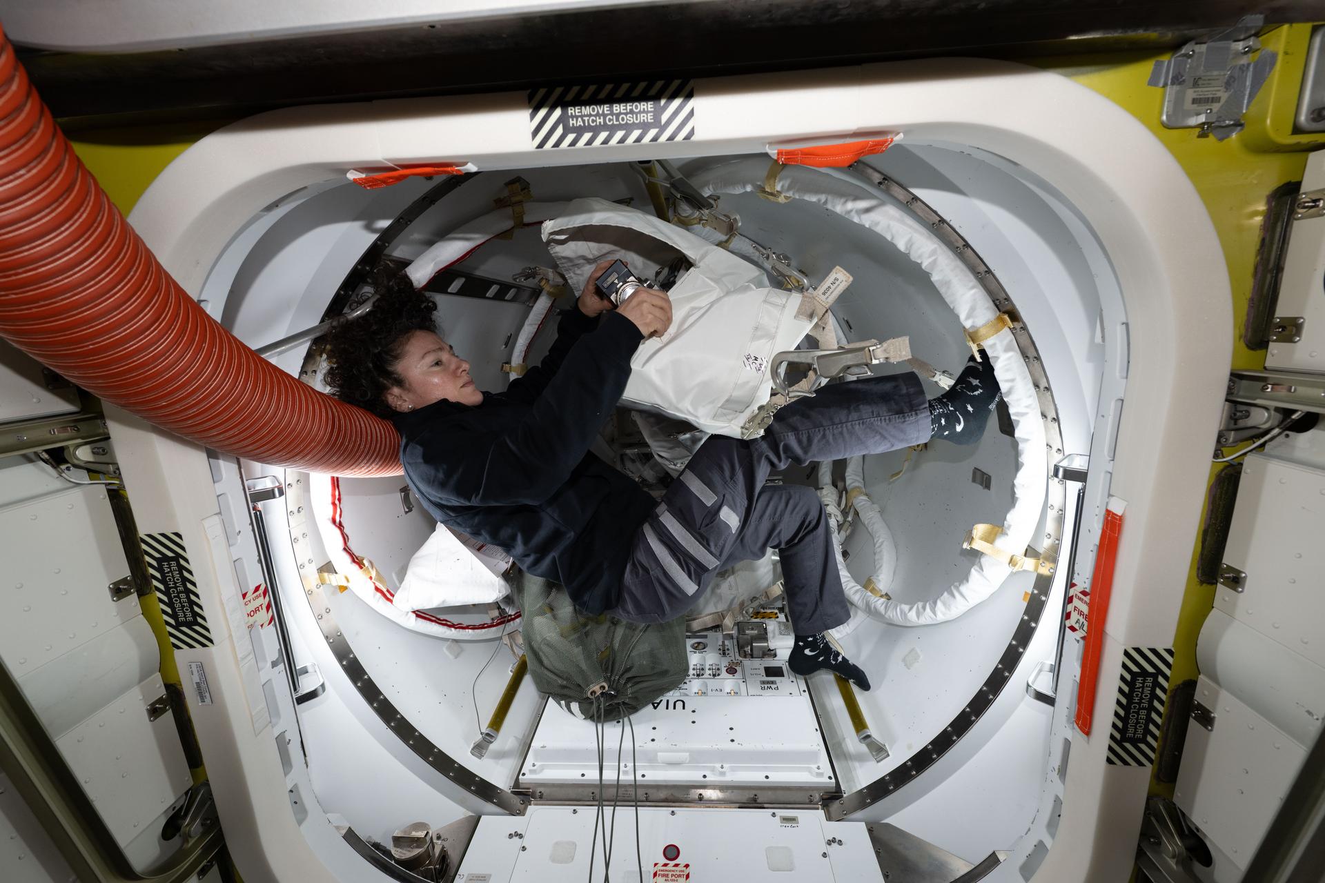 iss075e0002830 (Aug. 5, 2026) --- NASA astronaut and Expedition 75 commander Jessica Meir organizes tools inside the Quest airlock a day before her spacewalk, during which she installed hardware on the International Space Station's Starboard 6 truss segment to prepare it for future power system upgrades. Credit: NASA/Anil Menon