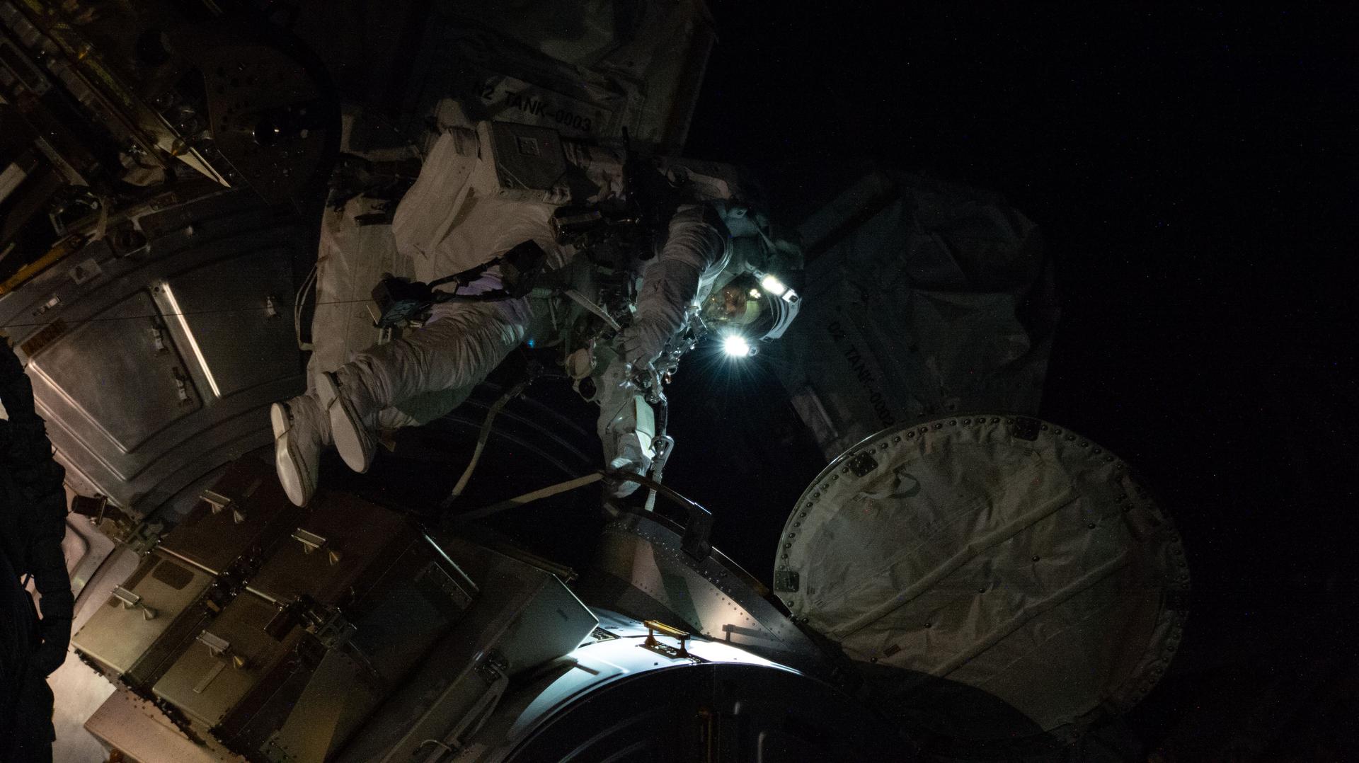 NASA astronaut and Expedition 75 flight engineer Anil Menon is pictured outside the International Space Station’s Quest airlock during a spacewalk, with his spacesuit’s helmet lights illuminating the worksite during an orbital night period. Menon helped build a modification kit on the station’s Starboard 6 truss segment, where a roll out solar array is slated to be installed later this year.