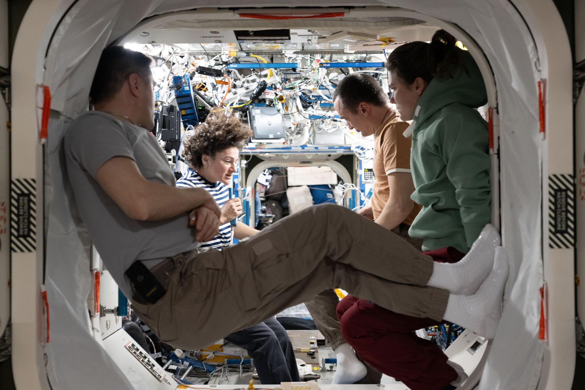 Four Expedition 75 crew members gather together and review procedures for emergency scenarios such as a pressure leak, a chemical leak, or a fire aboard the International Space Station. From left are, flight engineer Andrey Fedyaev of Roscosmos, station commander Jessica Meir of NASA, and Roscosmos flight engineers Pyotr Dubrov and Anna Kikina.