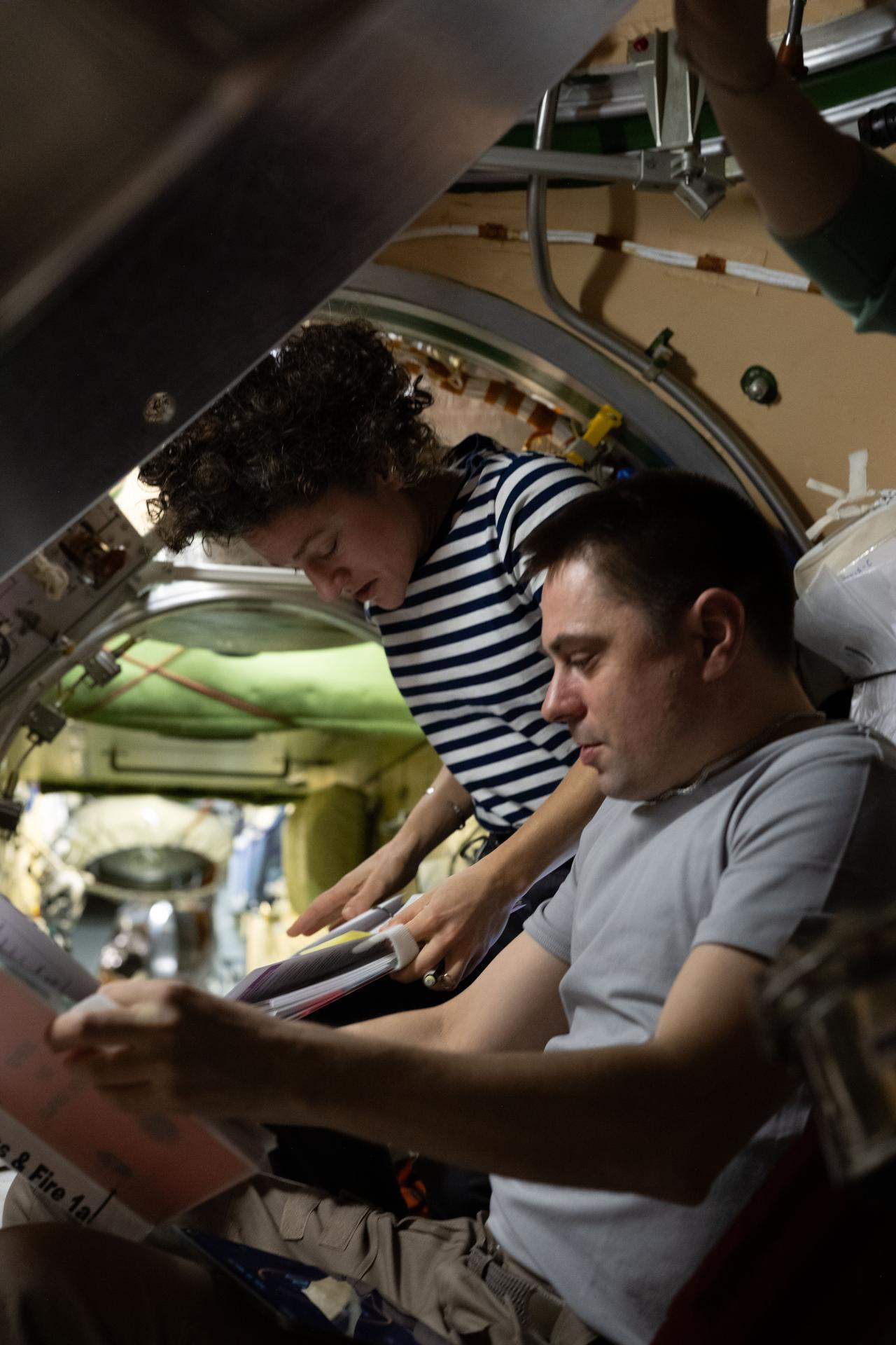 Expedition 75 commander Jessica Meir of NASA and flight engineer Andrey Fedyaev of Roscosmos review procedures for emergency scenarios such as a pressure leak, a chemical leak, or a fire aboard the International Space Station.