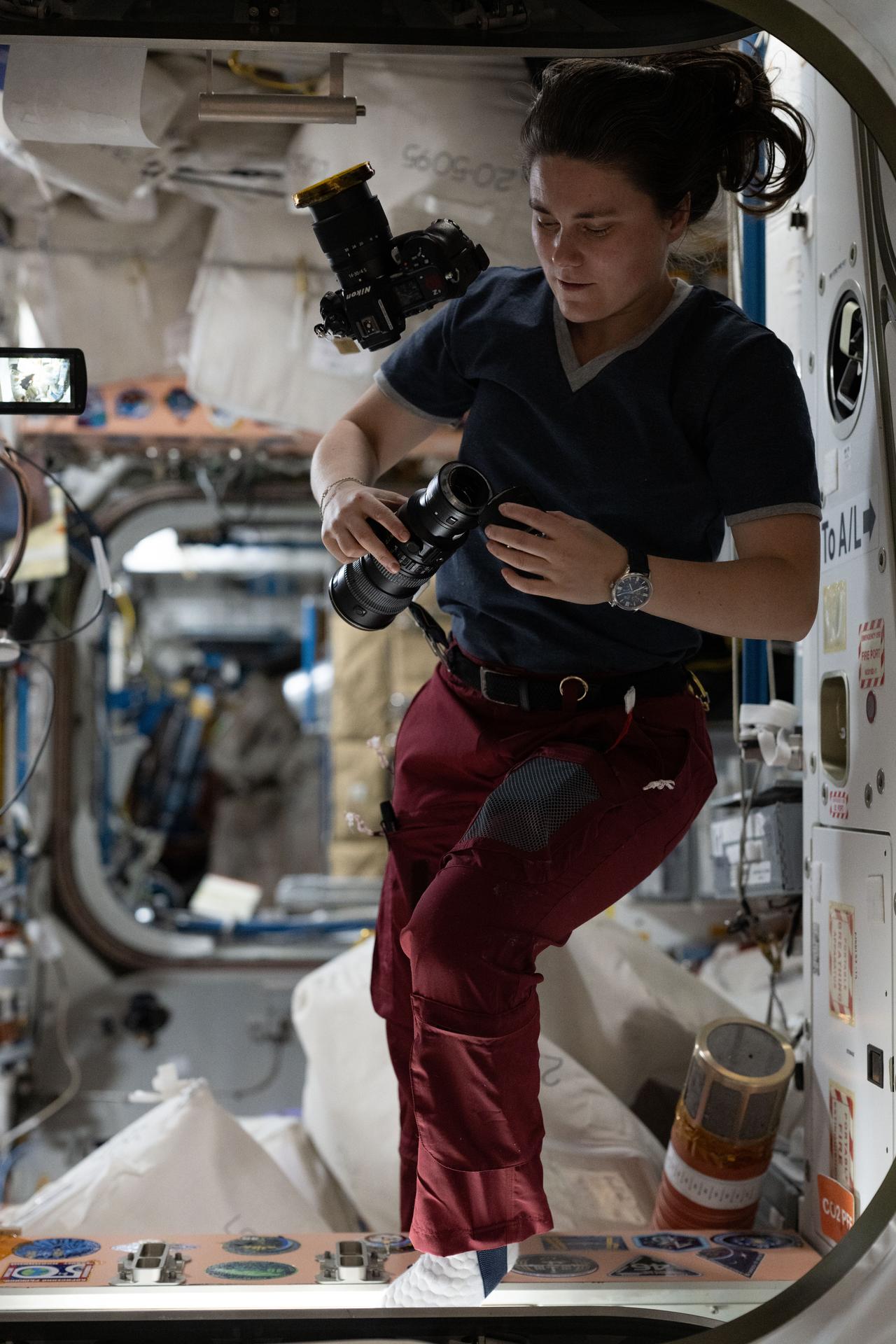 Roscosmos cosmonaut and Expedition 75 flight engineer Anna Kikina checks cameras and lenses aboard the International Space Station.