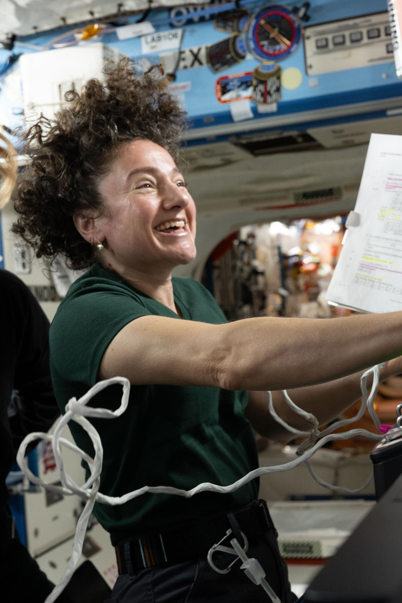 Expedition 75 commander Jessica Meir smiles during a light moment while studying Canadarm2 robotic arm procedures to support spacewalk operations to replace a space‑to‑ground antenna outside the International Space Station.