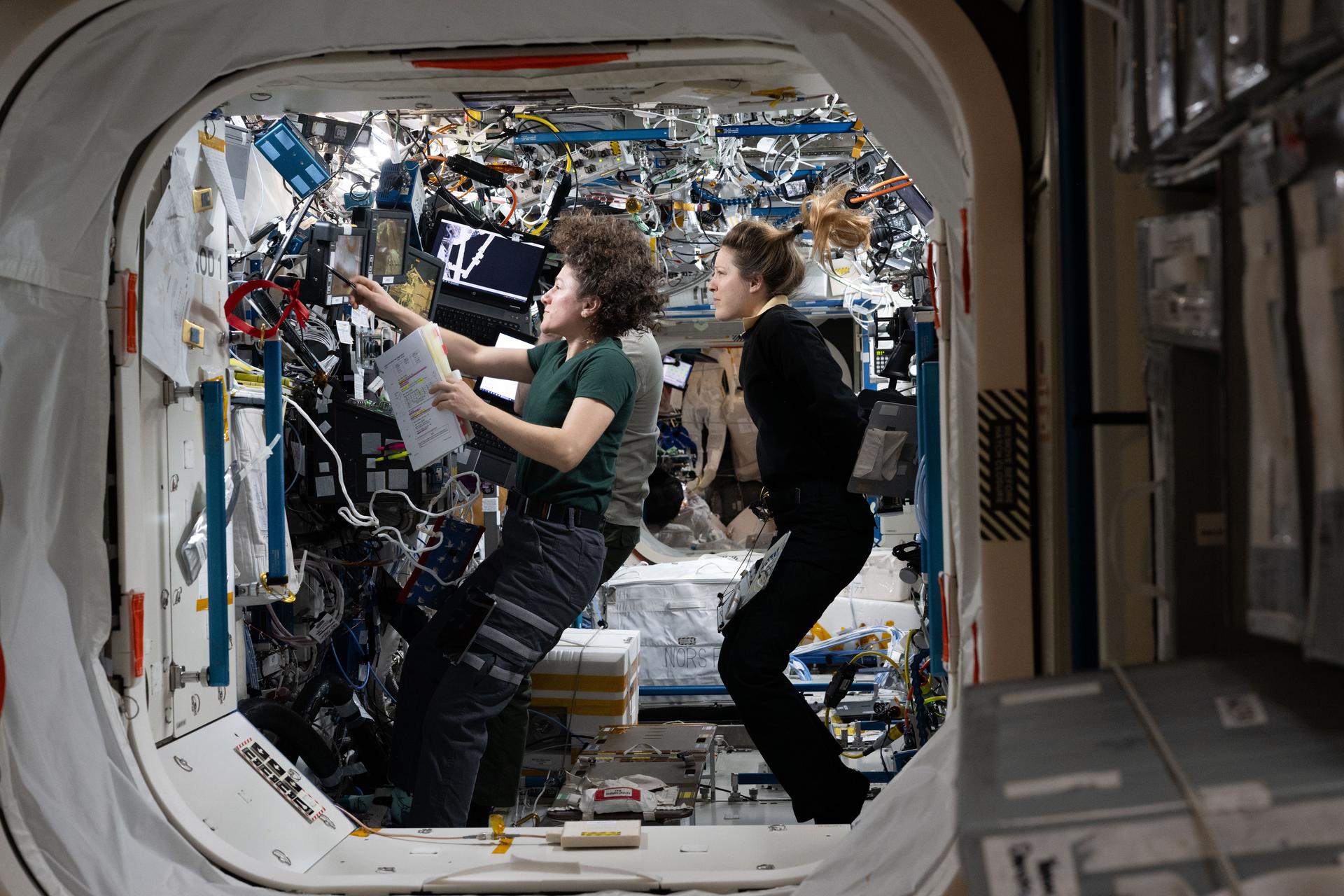Expedition 75 commander Jessica Meir of NASA and flight engineer Sophie Adenot of ESA (European Space Agency) study Canadarm2 robotic arm procedures to support spacewalk operations to replace a space‑to‑ground antenna outside the International Space Station.
