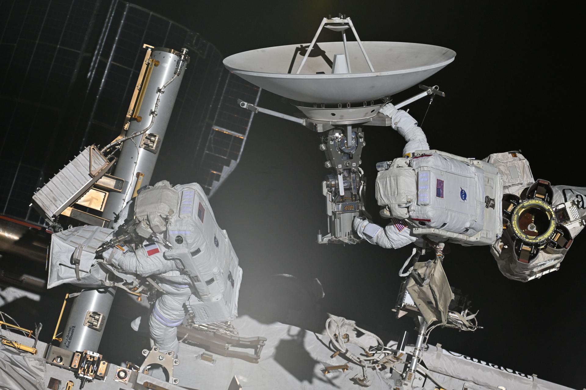 From left, Expedition 75 flight engineers Sophie Adenot of ESA (European Space Agency) and Anil Menon of NASA work together during a six‑hour, 23‑minute spacewalk outside the International Space Station. Adenot worked at the Z1 truss segment while Menon rode the Canadarm2 robotic arm and carried a space-to-ground antenna, which the duo later tied down to the Z1.
