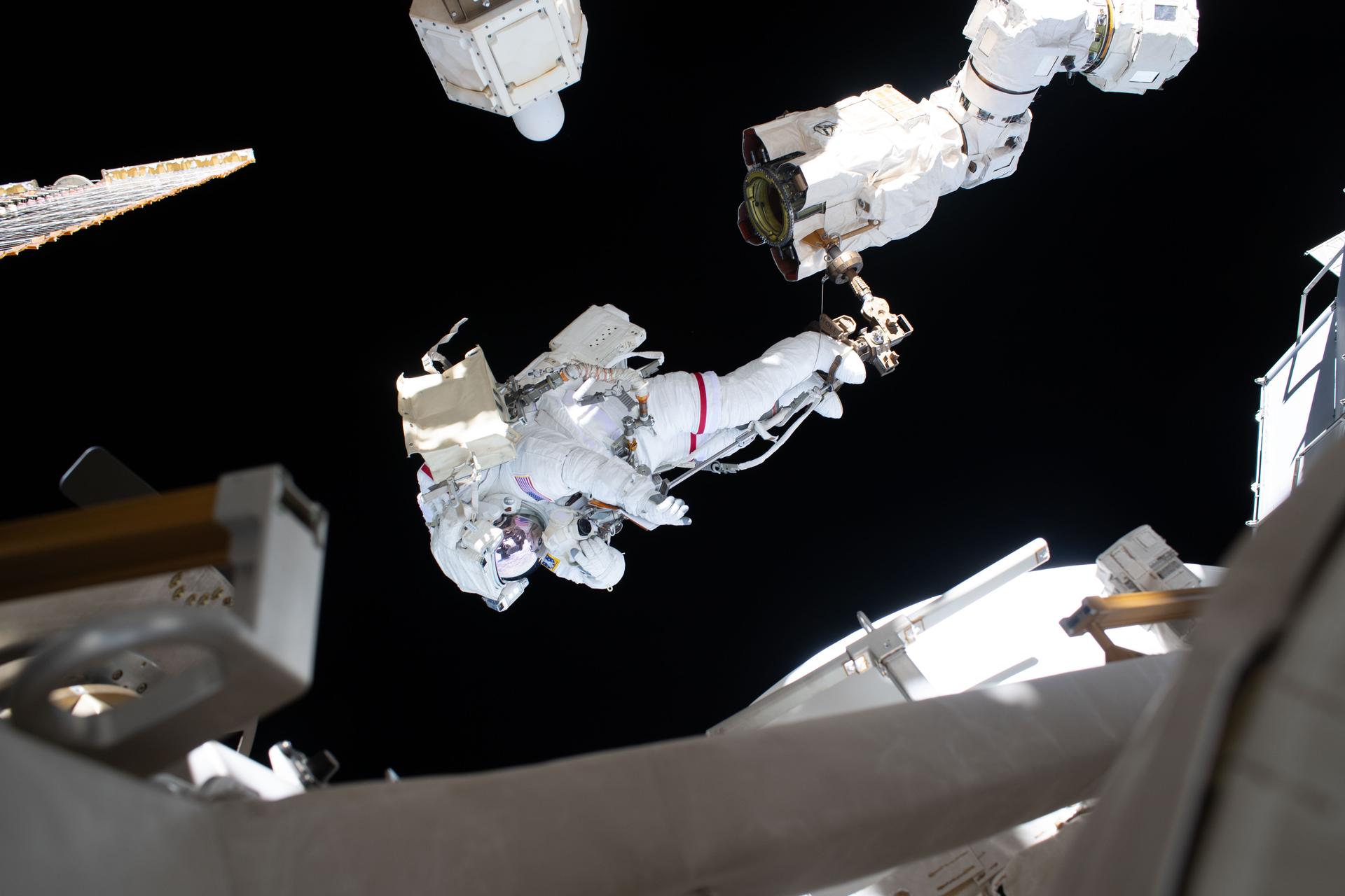 NASA astronaut and Expedition 75 flight engineer Anil Menon is attached to the Canadarm2 robotic arm’s latching end effector during a spacewalk to install a high-speed space-to-ground antenna on the International Space Station’s Z1 truss segment above the Unity module. Menon and ESA (European Space Agency) astronaut and Expedition 75 flight engineer Sophie Adenot (out of frame) spent six hours and 30 minutes replacing a failed antenna with a spare and making the precise connections needed to activate it for high-speed transmissions with mission control.